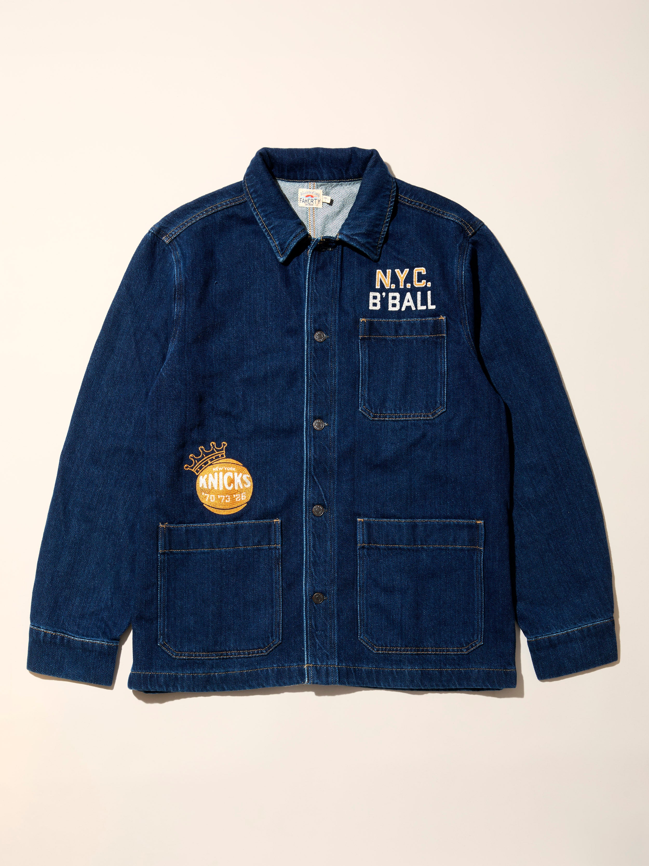 Blue denim jacket with embroidered N.Y.C. B' Ball and NY Knicks graphic on a beige background