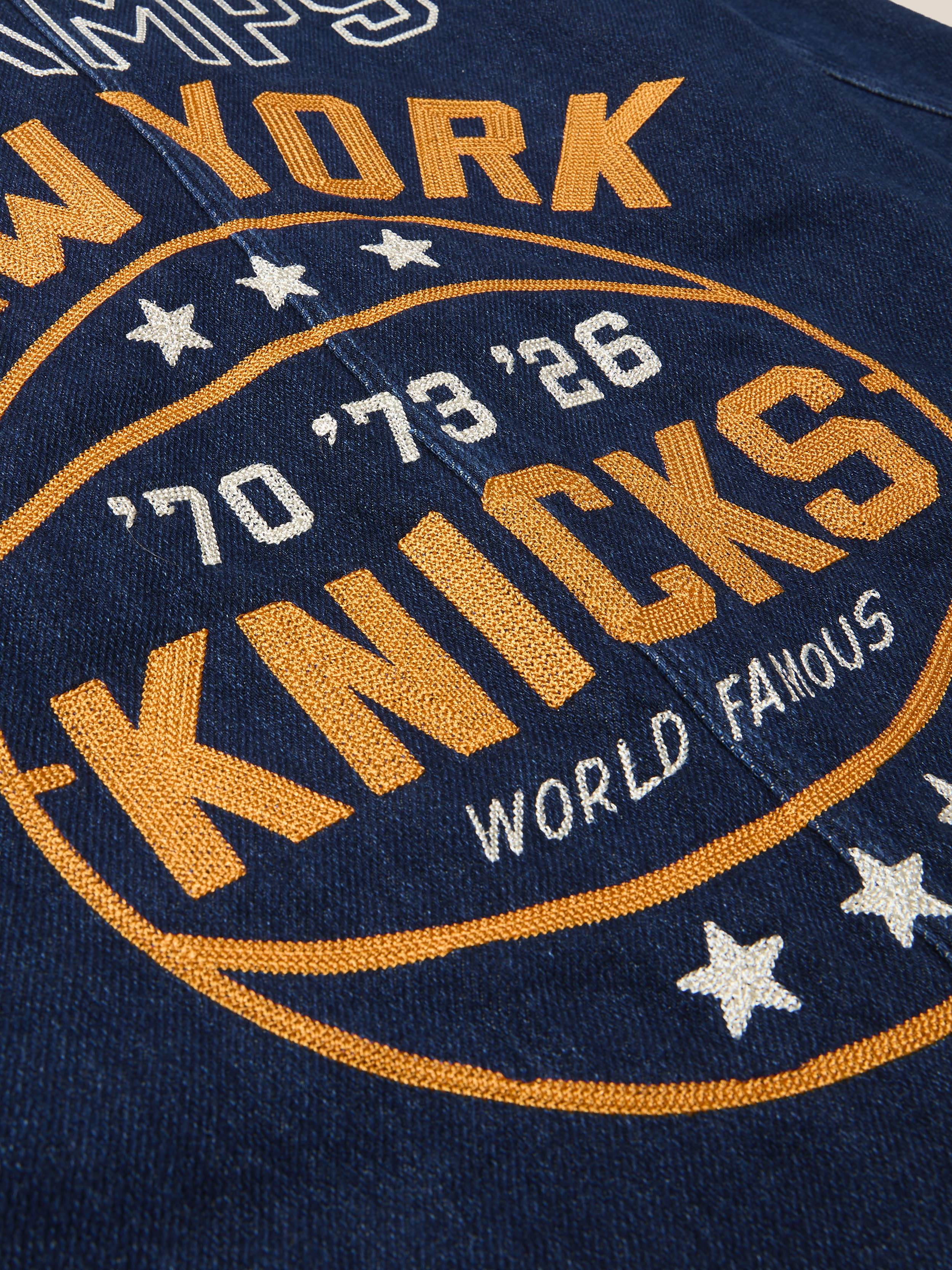 Embroidered design on a denim jacket with embroidered New York Knicks graphic on the back