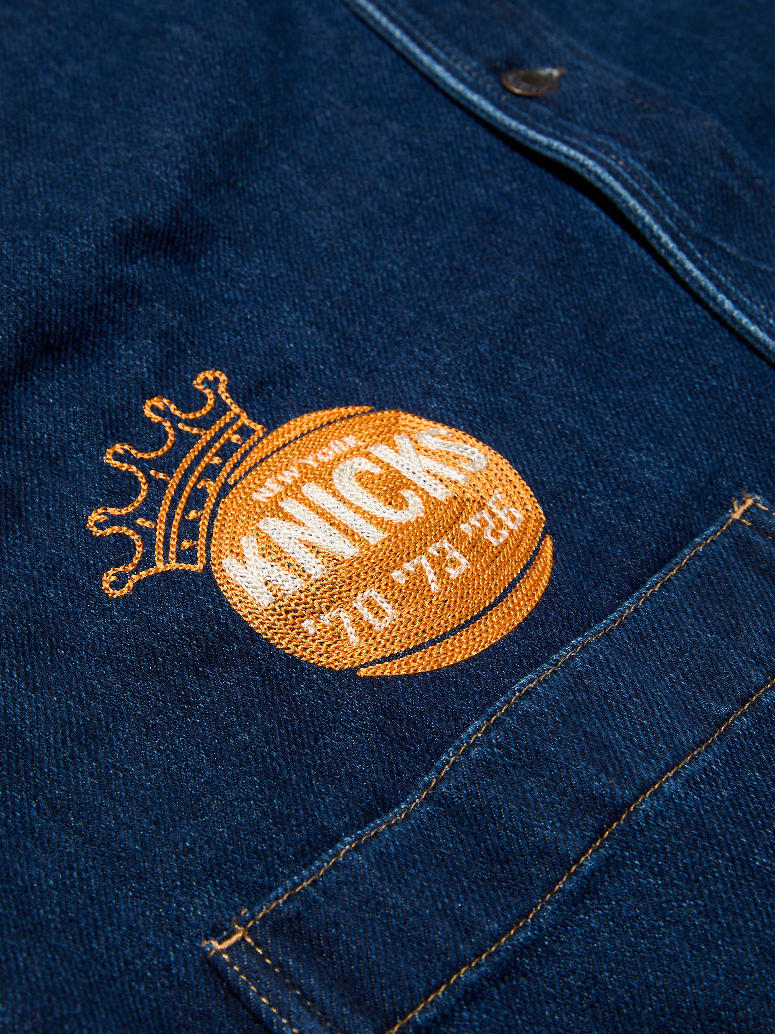 Embroidered NY Knicks graphic on a blue denim jacket