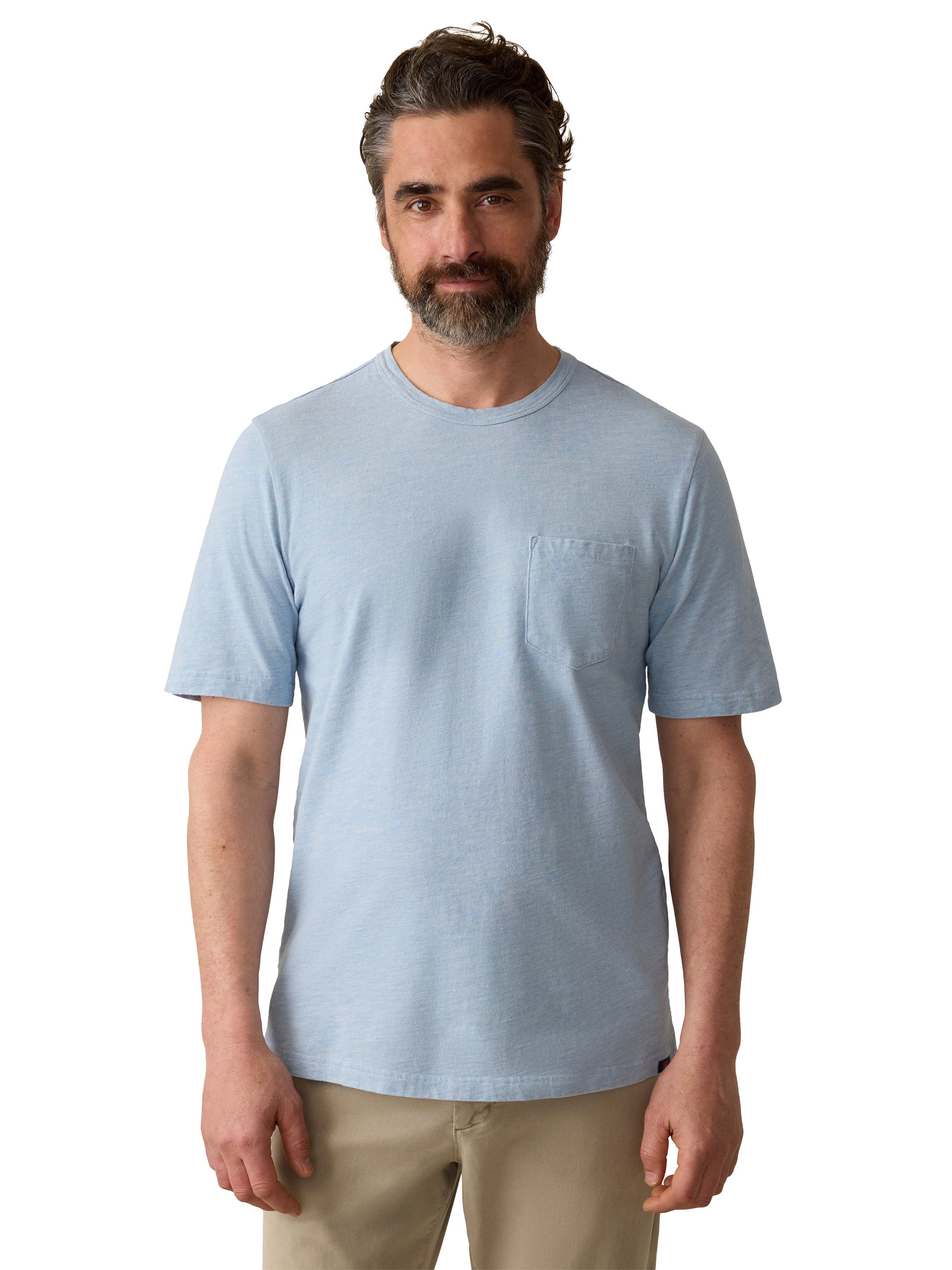 A man wearing a blue tee and beige pants