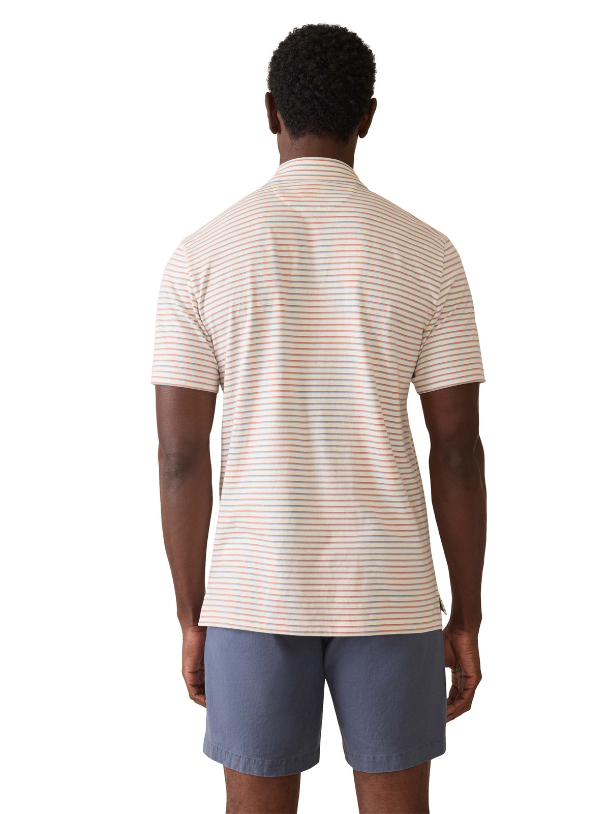 A man viewed from behind wearing a striped polo shirt and blue shorts, image 3 of 3