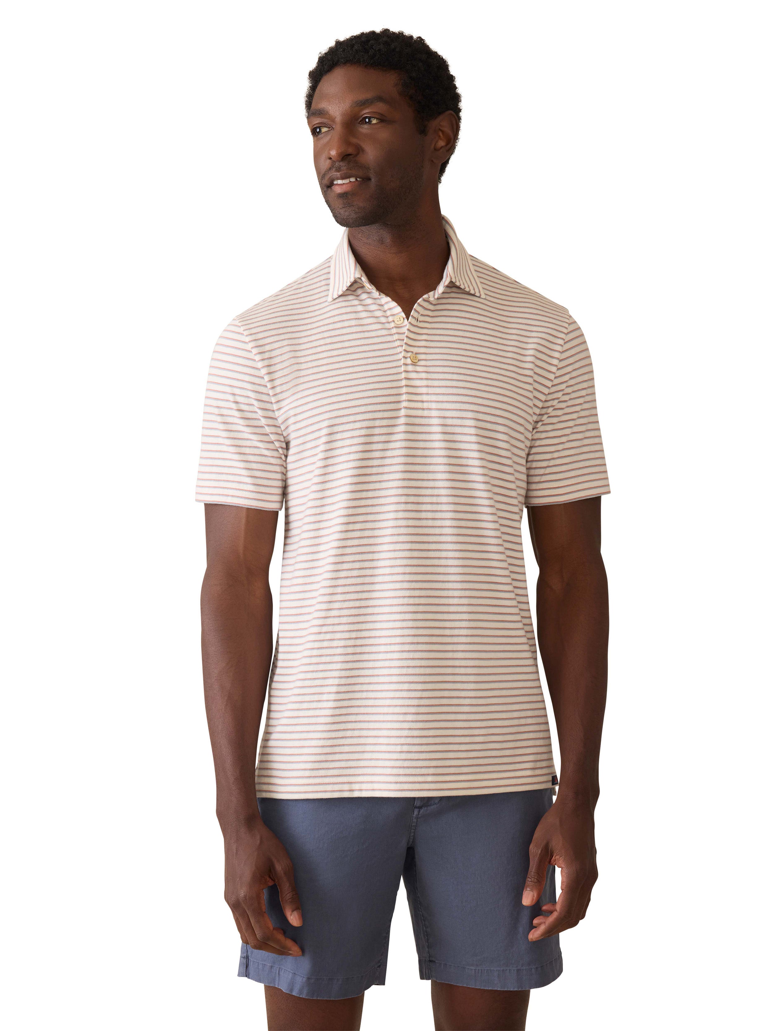 A man wearing a striped polo shirt and blue shorts