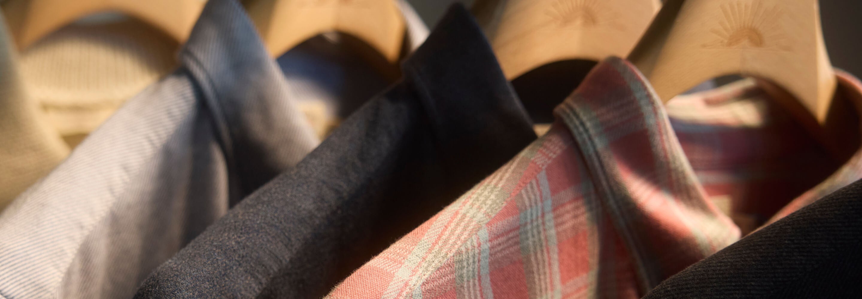 Collection of coastline knit shirts hanging on a garment rack
