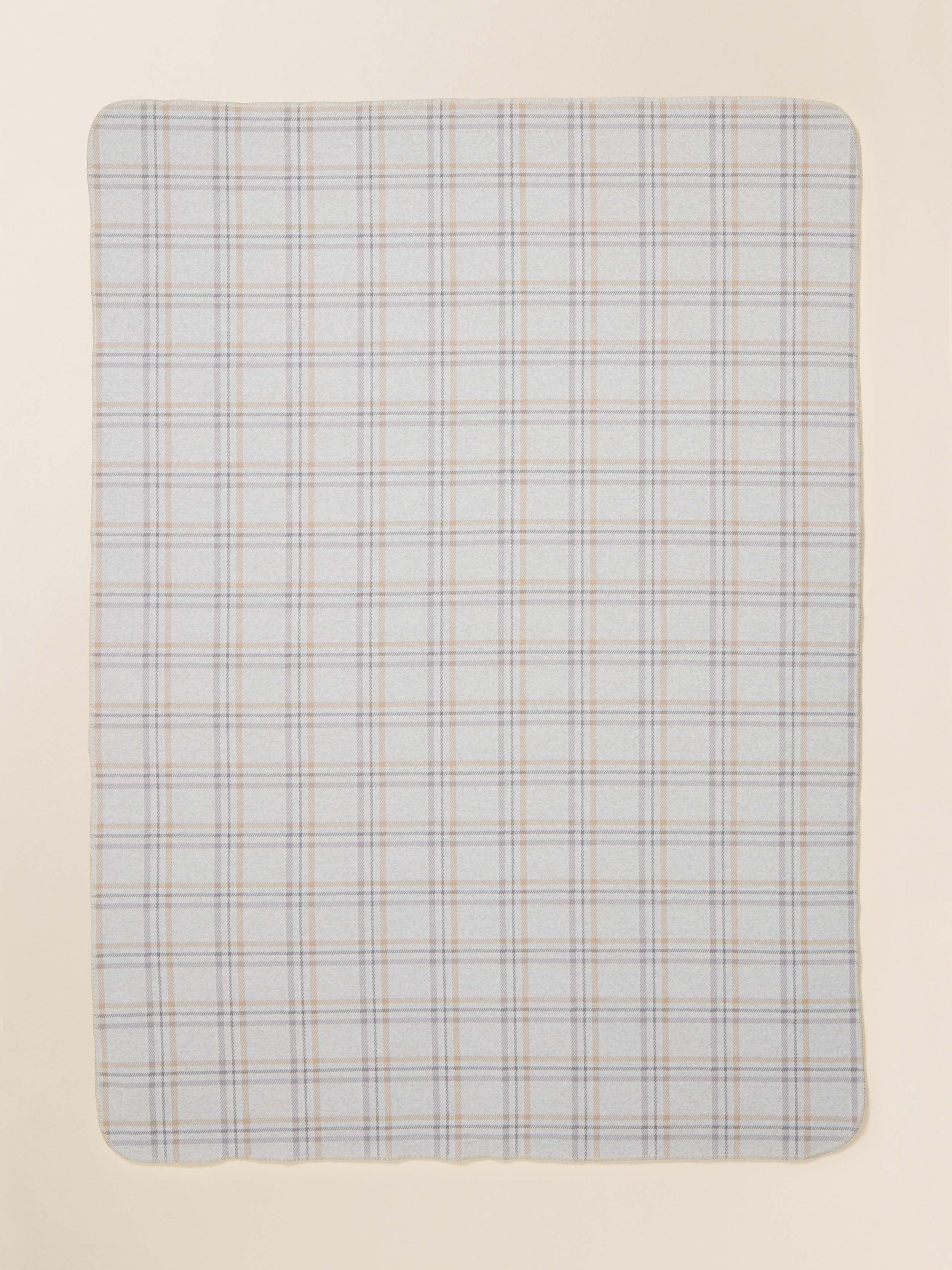 Light blue plaid patterned blanket on a beige background