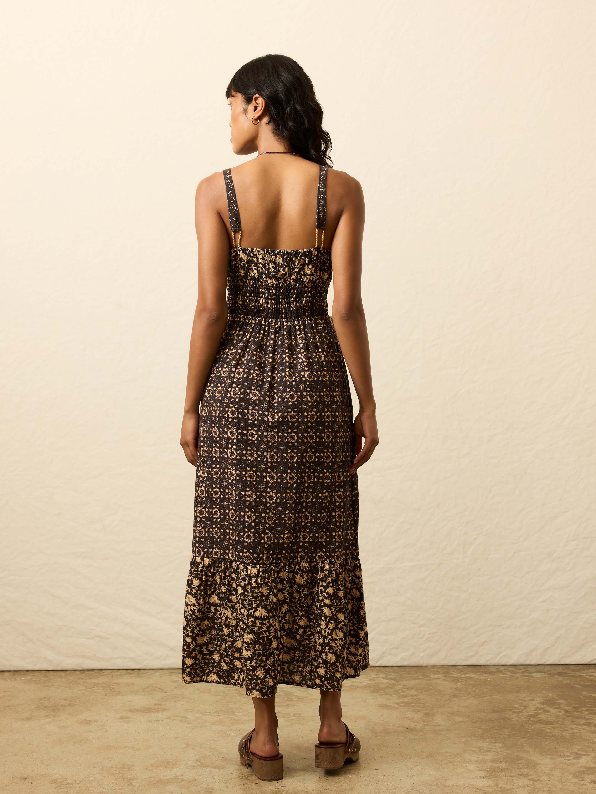 Woman is wearing a patterned dress against a beige background