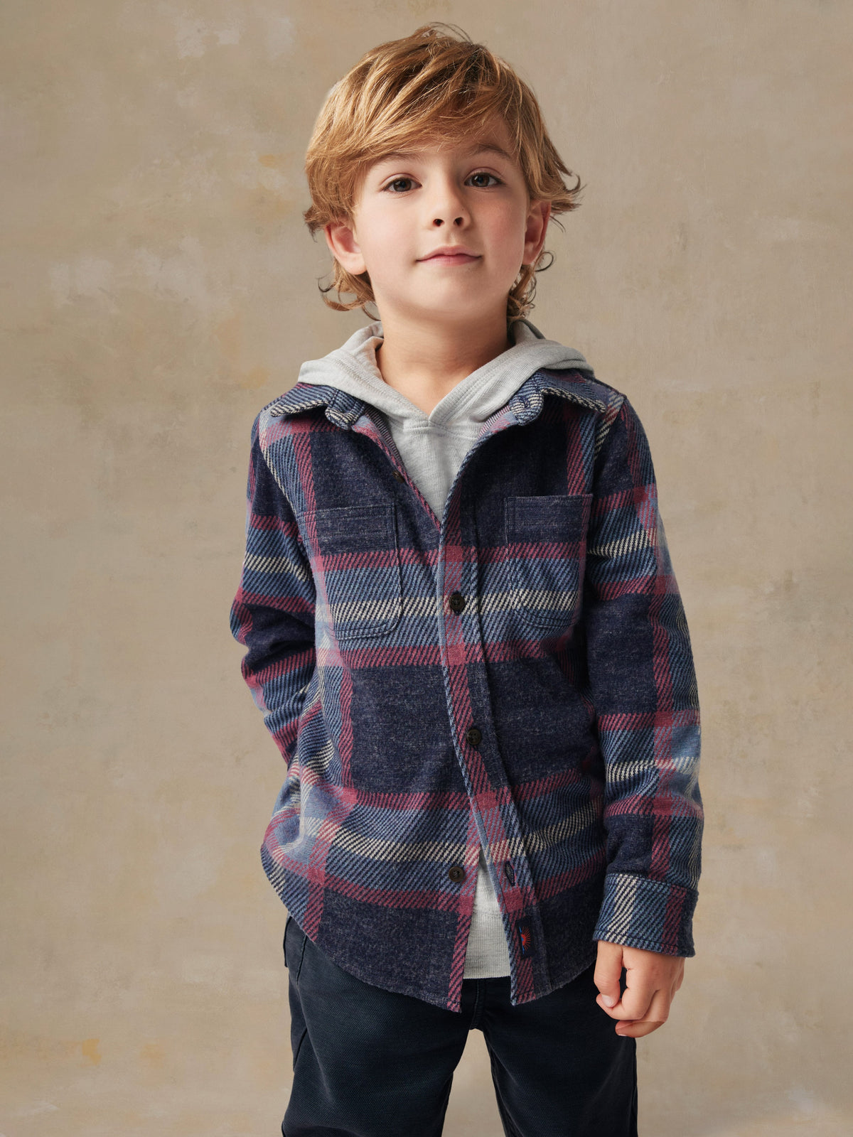 Close up of a child wearing a plaid shirt and black pants, image 2 of 6