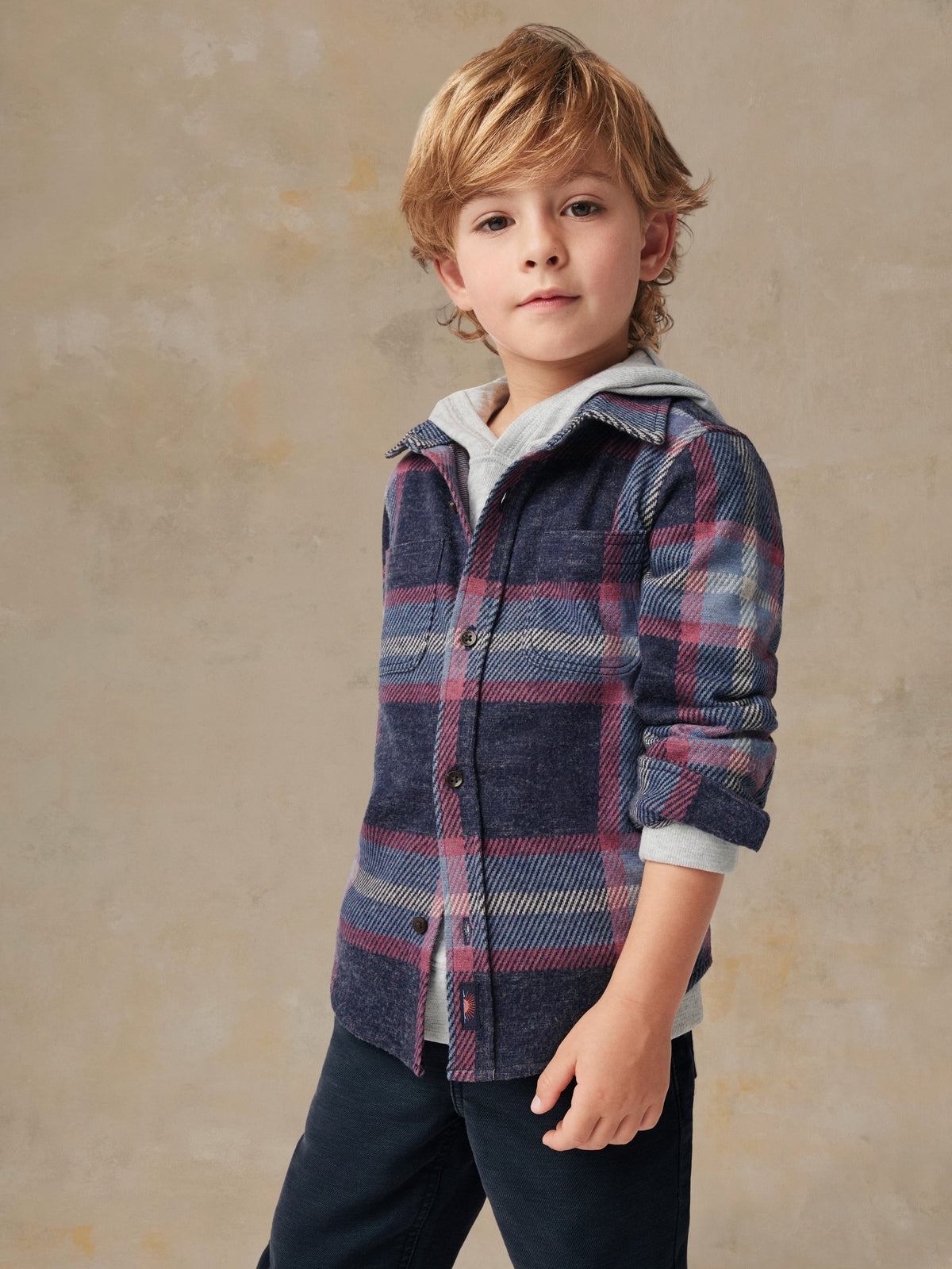 Close up of a child wearing a plaid shirt and black pants, image 4 of 6