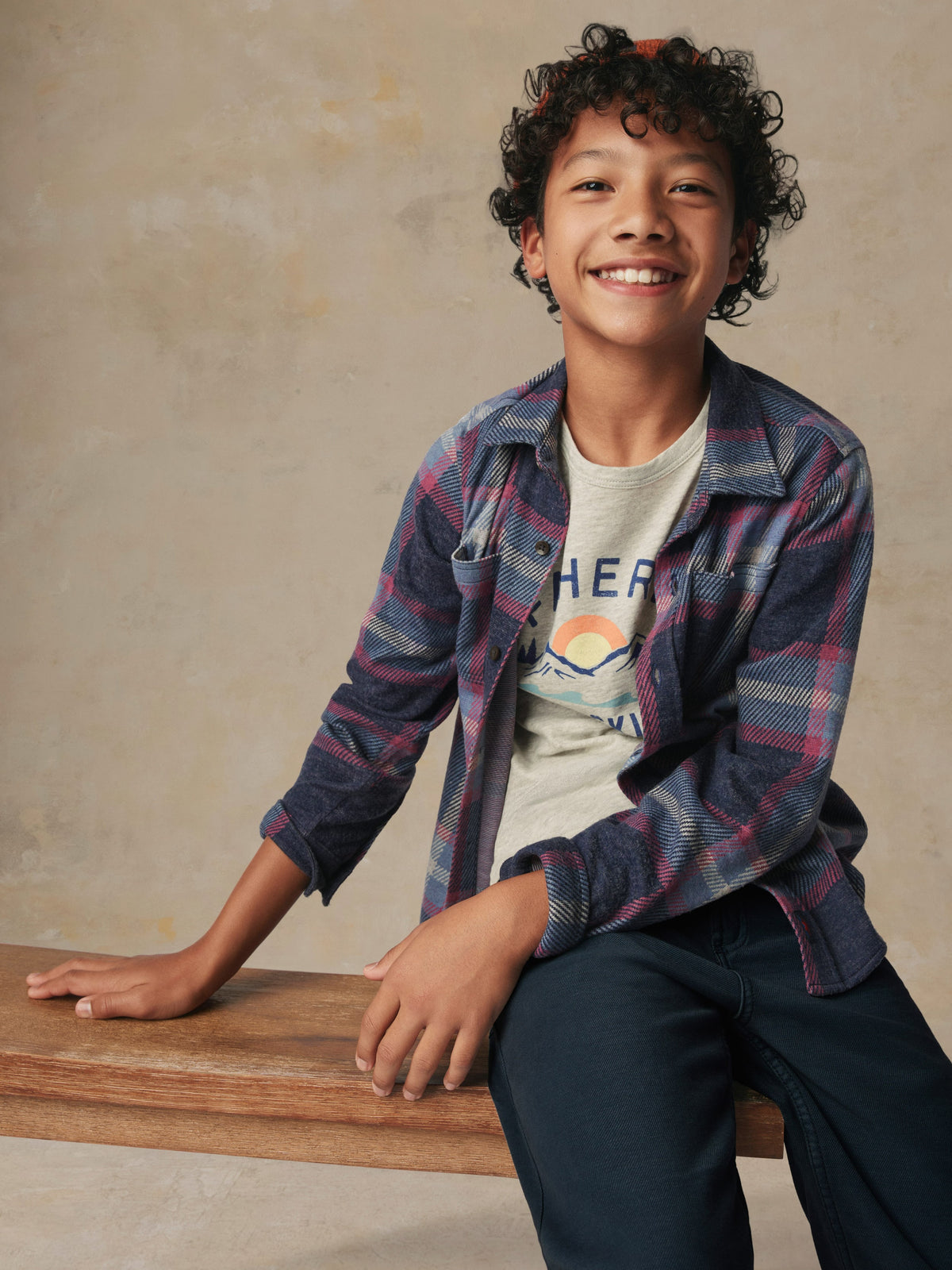 Close up of a child wearing a plaid button up shirt and black pants, image 4 of 6