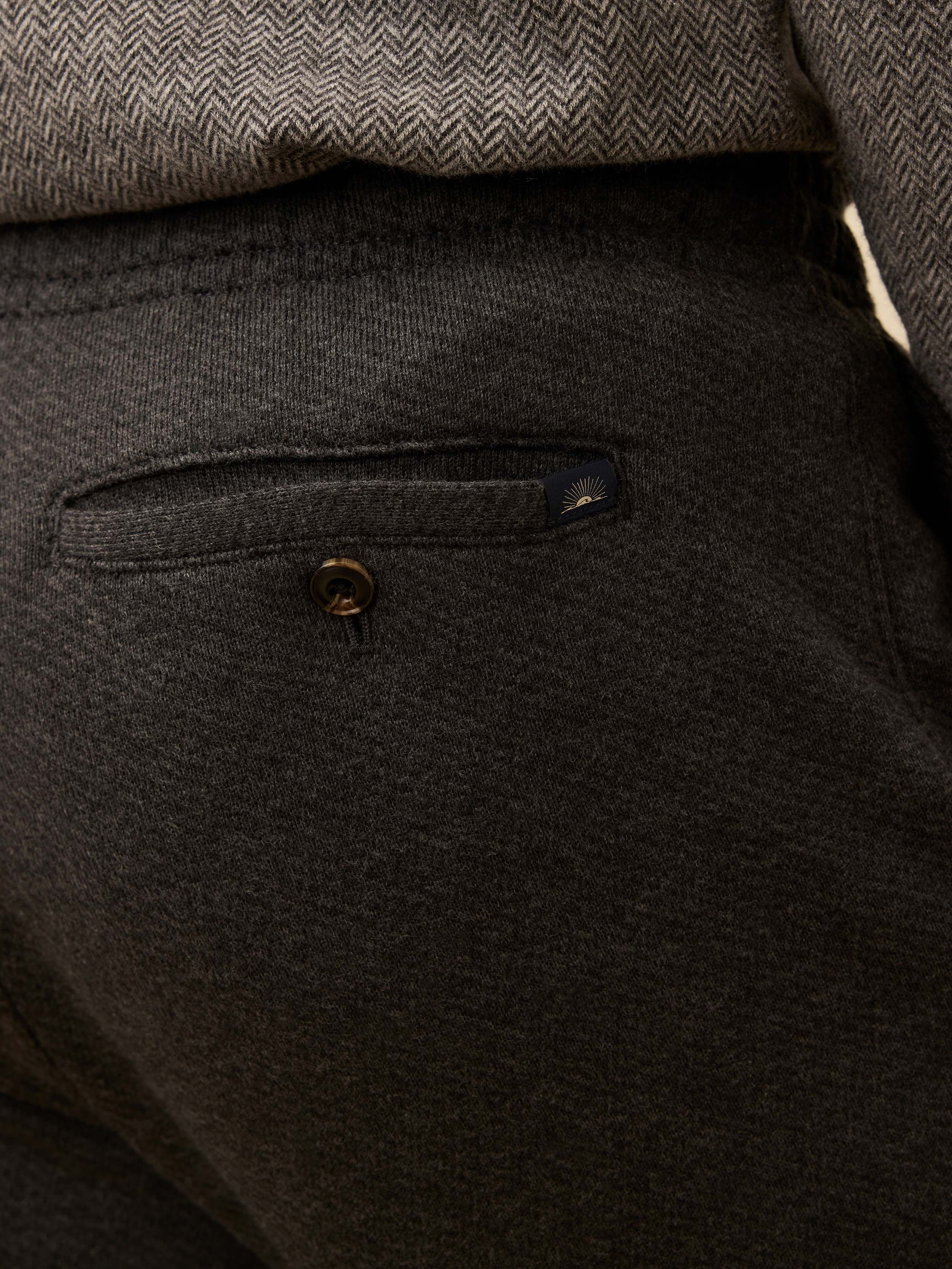 Dark gray pants with a button detail and Faherty branded logo