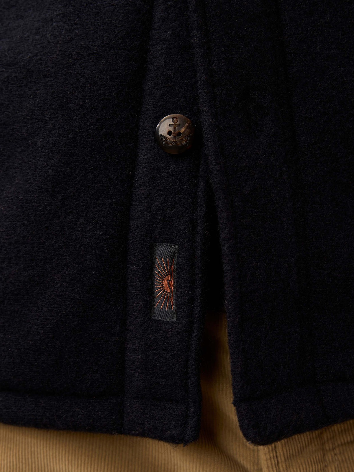 Close-up of a navy jacket with a button and Faherty brand label, image 6 of 6