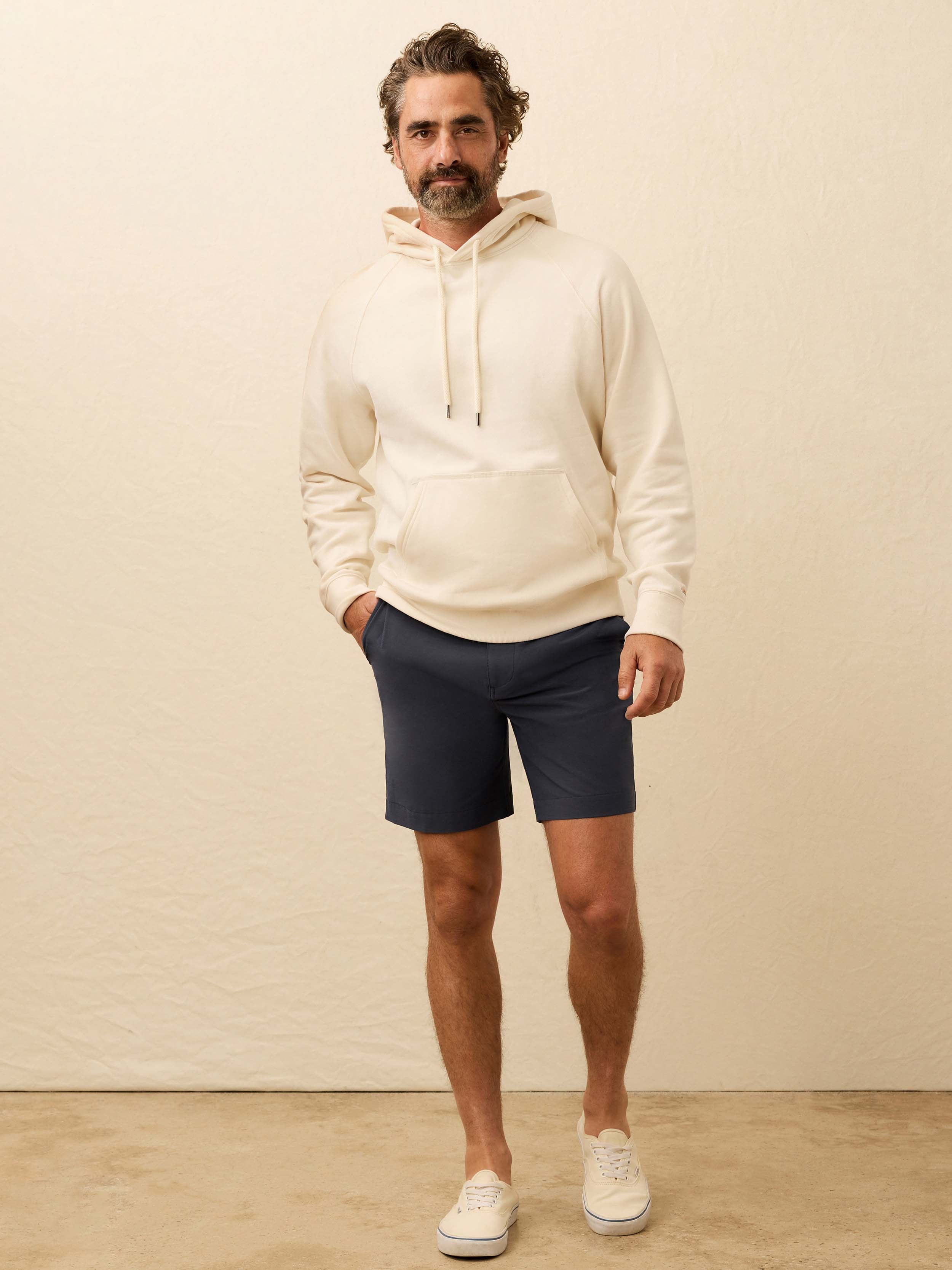 Man wearing a cream hoodie against a beige background