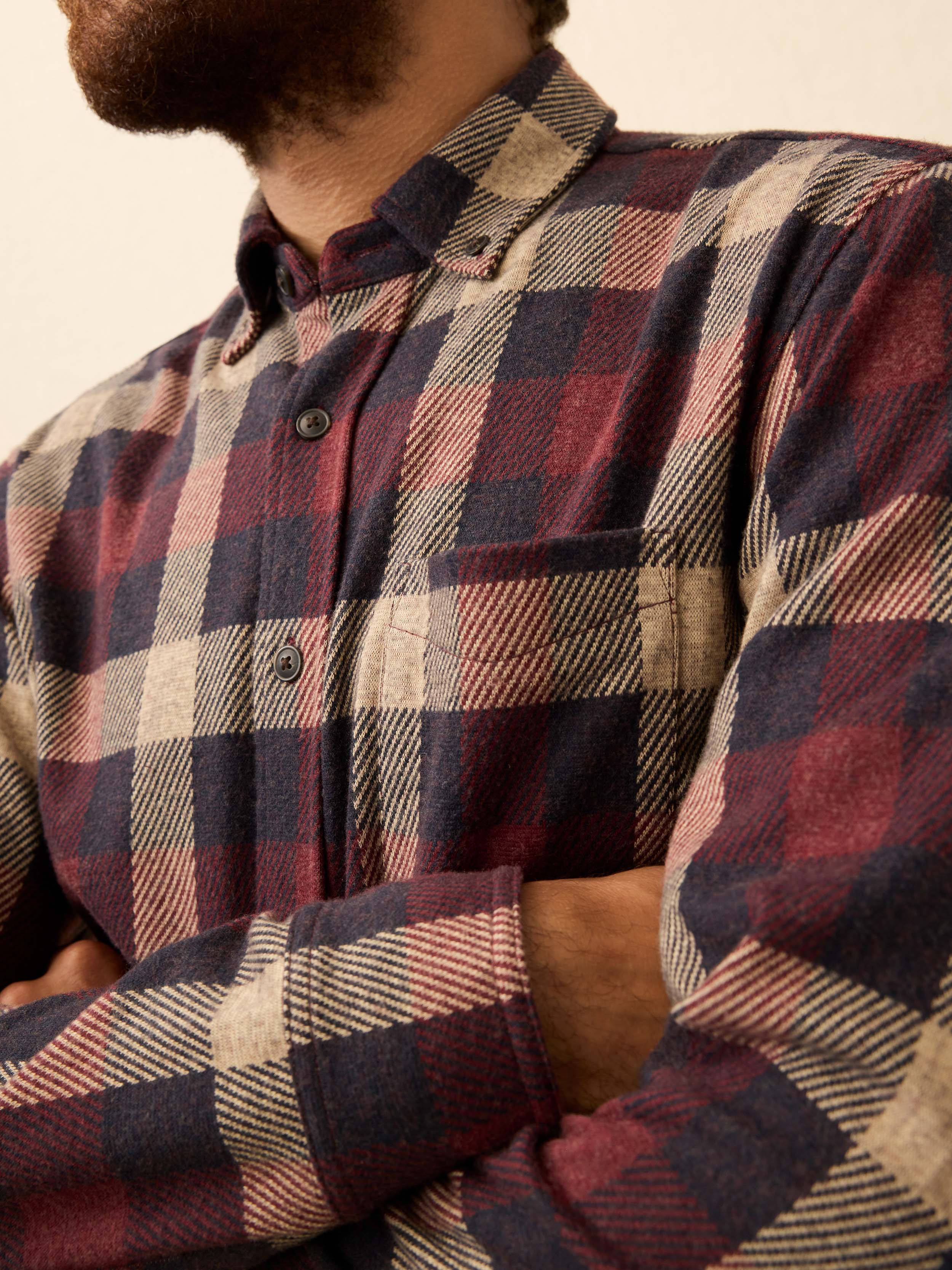 Man wearing a red plaid shirt against a beige background