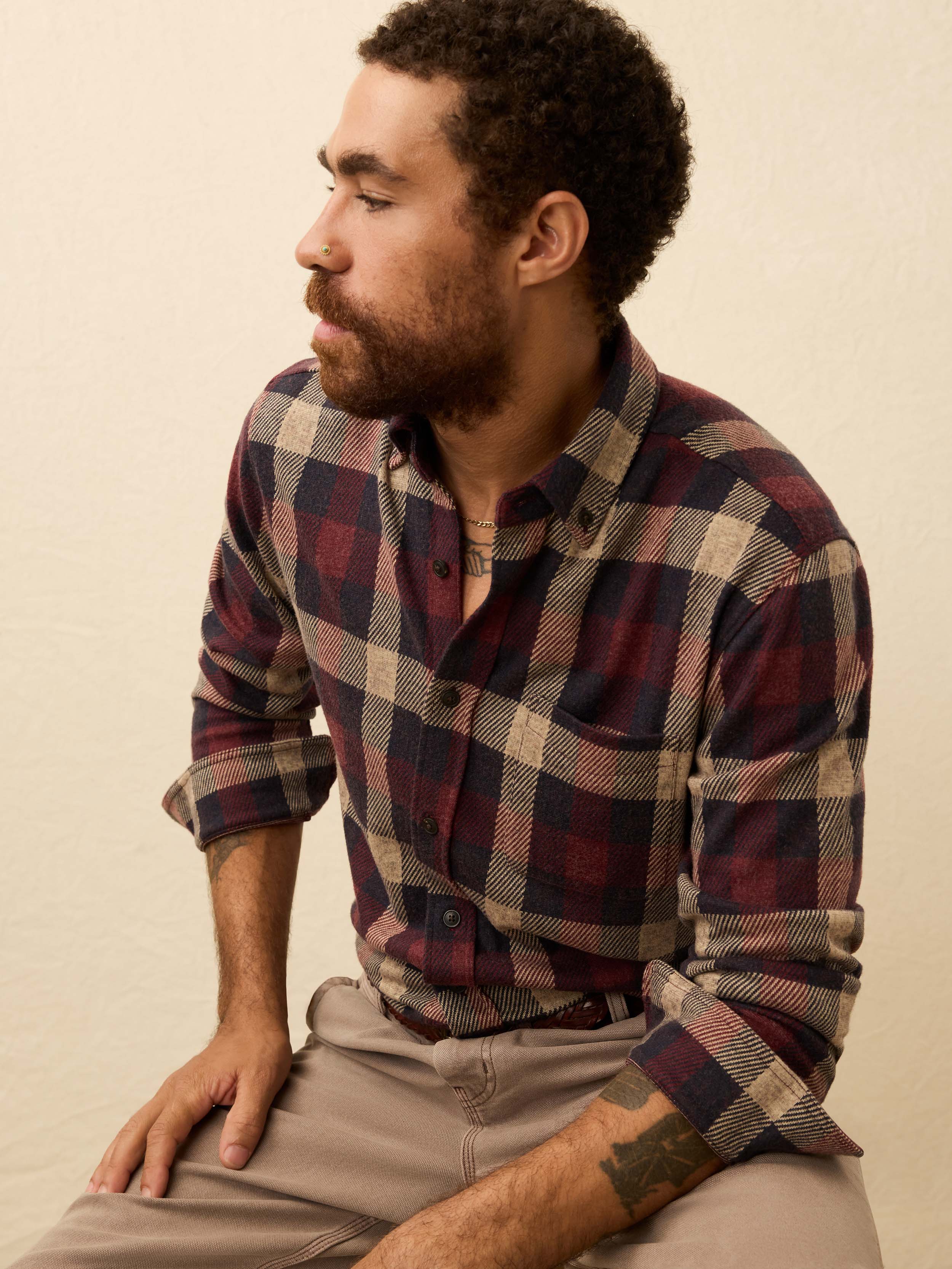 Man wearing a red plaid shirt against a beige background