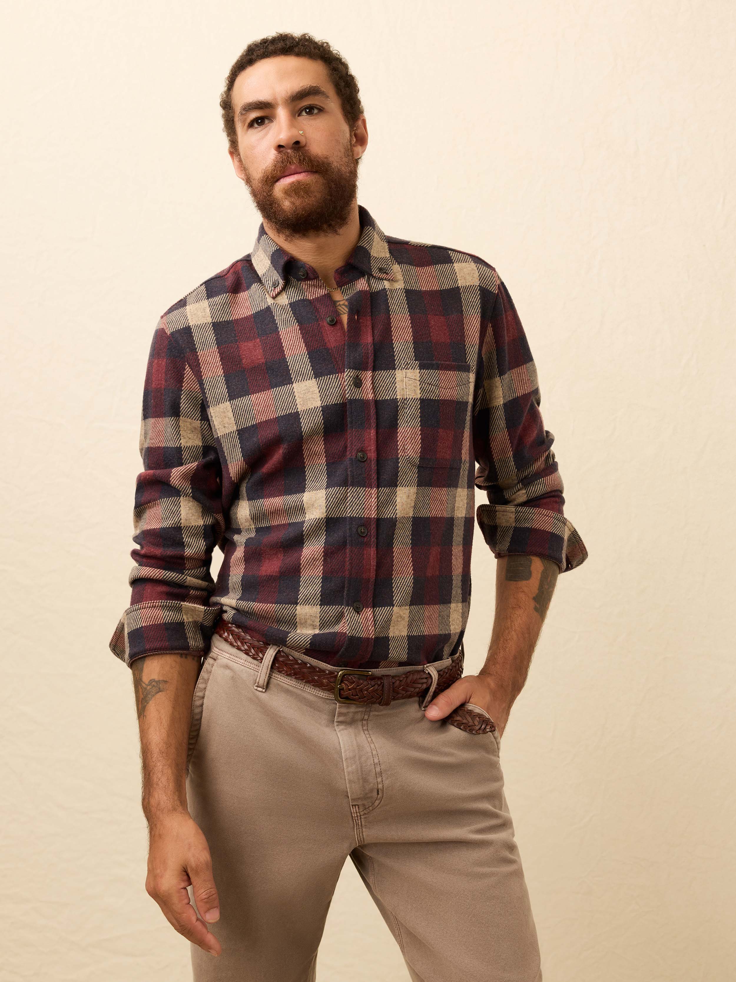 Man wearing a red plaid shirt against a beige background