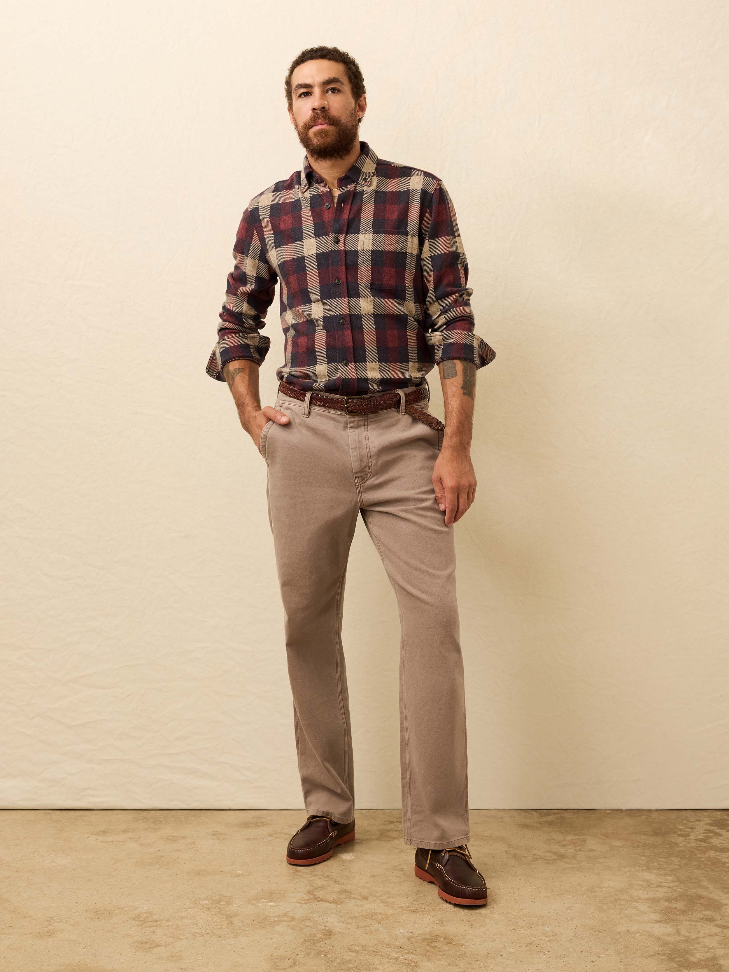 Man wearing a red plaid shirt against a beige background