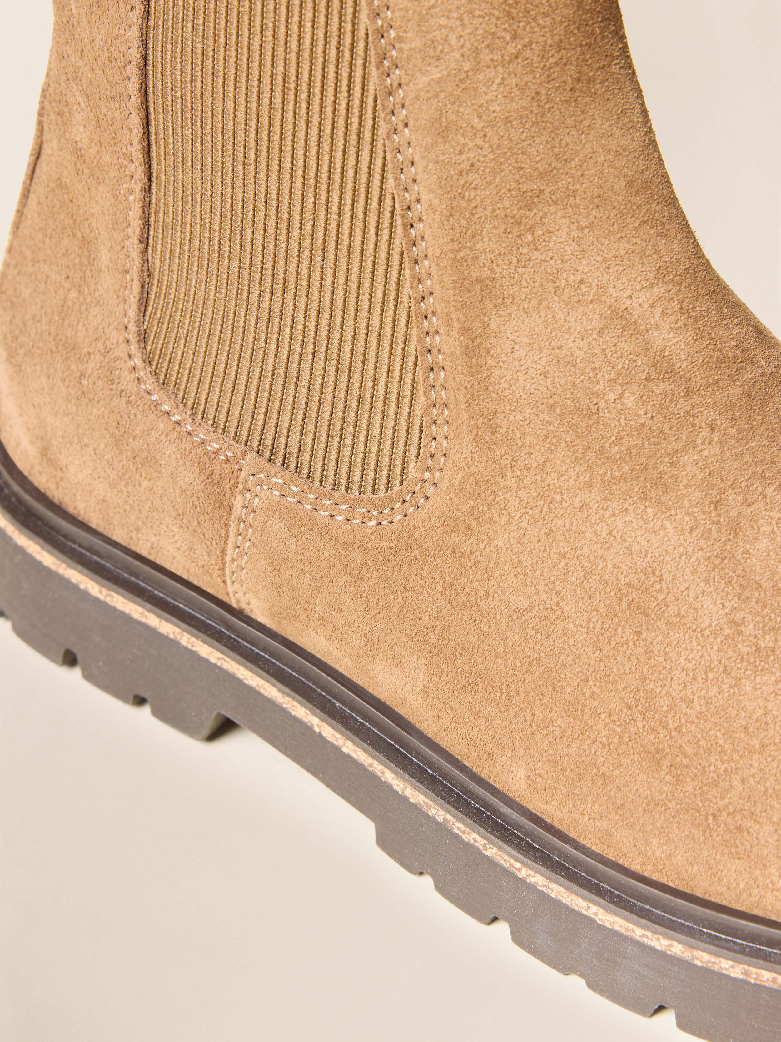 Close-up of a tan suede boot with a white background