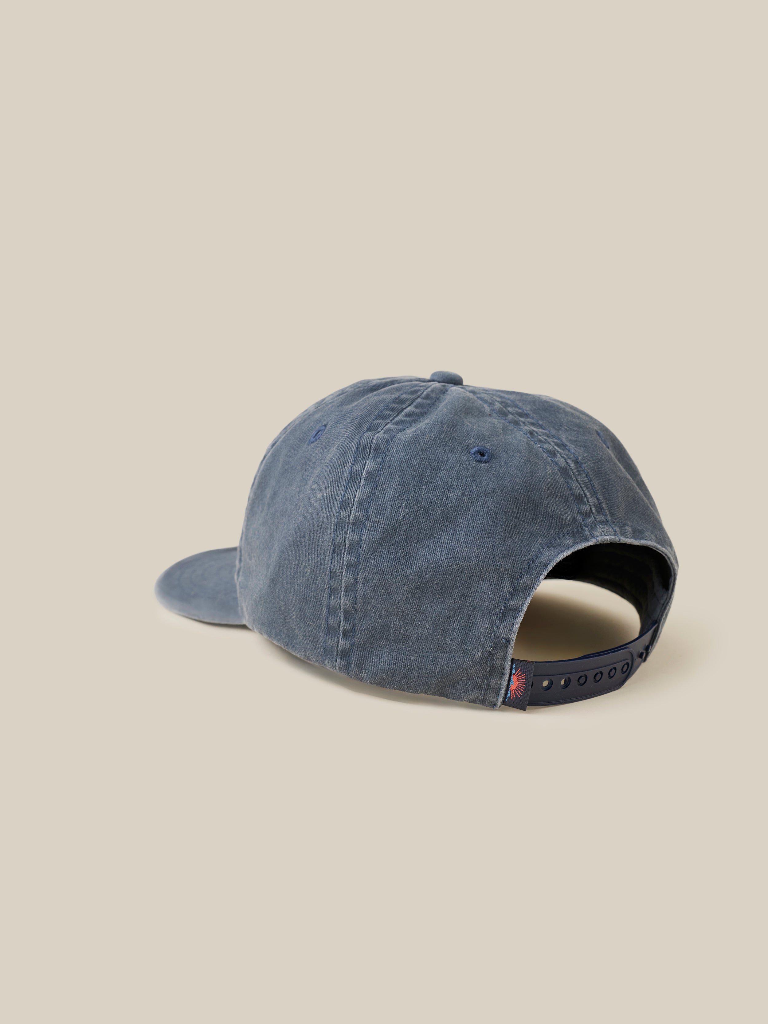 Blue cap with a Faherty label on the back on a beige background