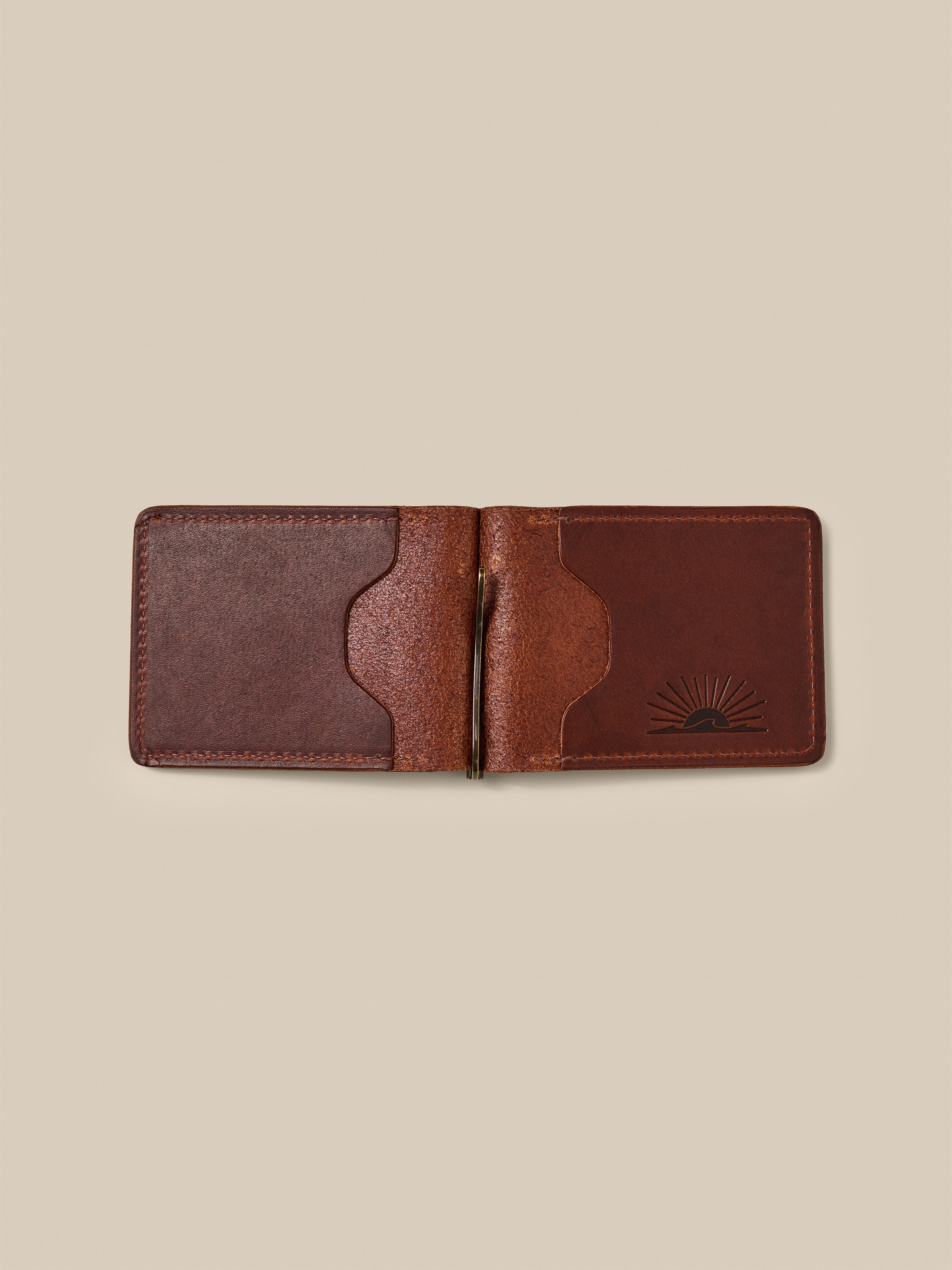 Brown leather money clip against a beige background