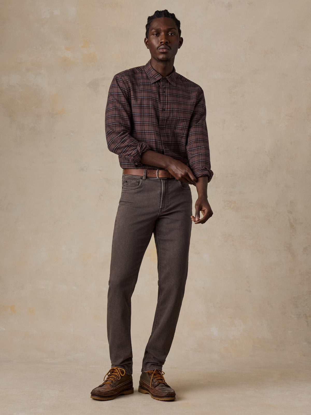 Man wearing a brown plaid shirt and brown pants, image 5 of 5