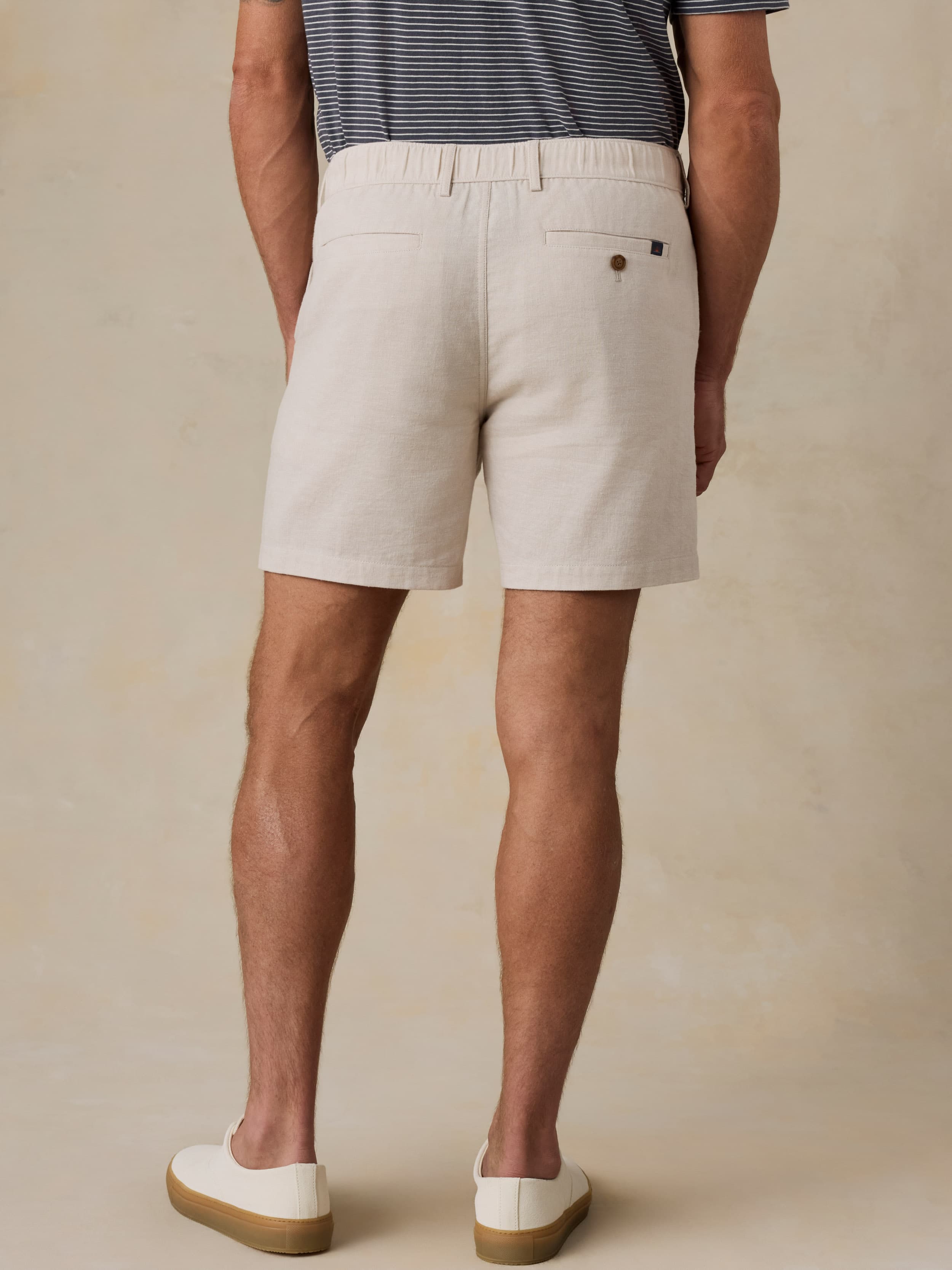 Man wearing beige shorts on a beige background