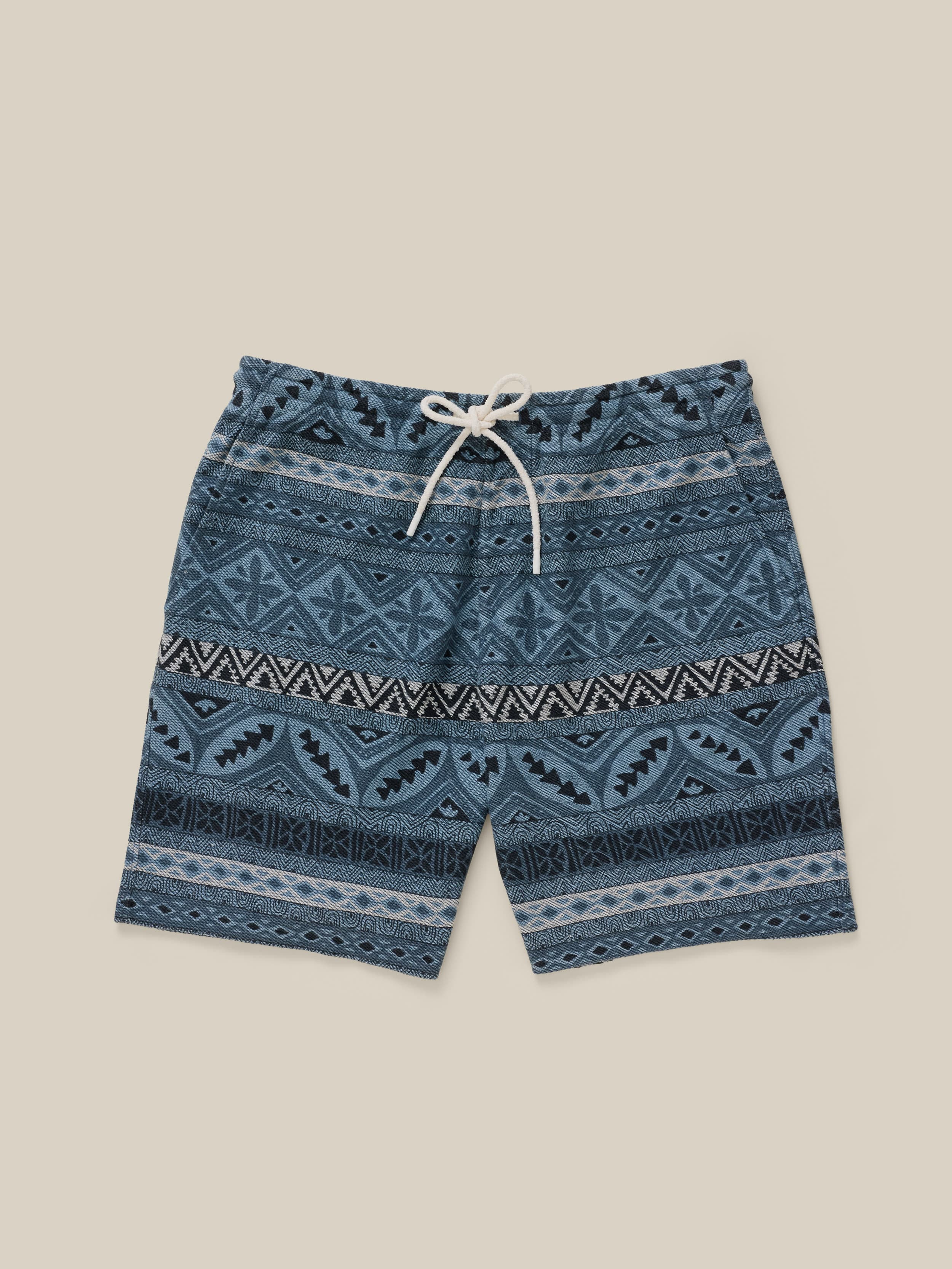 Blue patterned shorts on a beige background