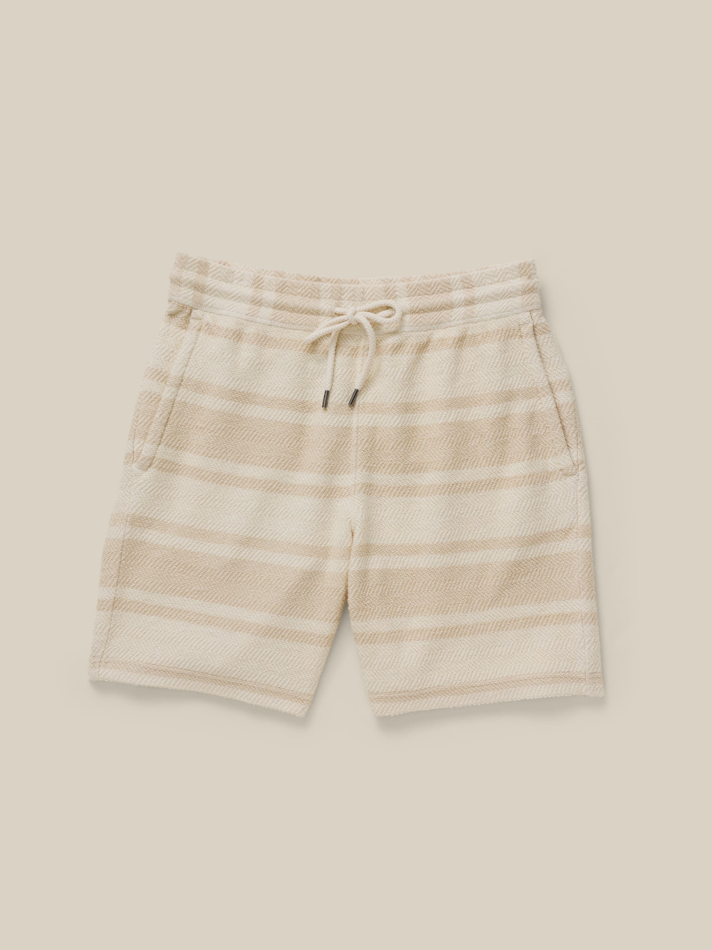 Beige striped shorts against a beige background