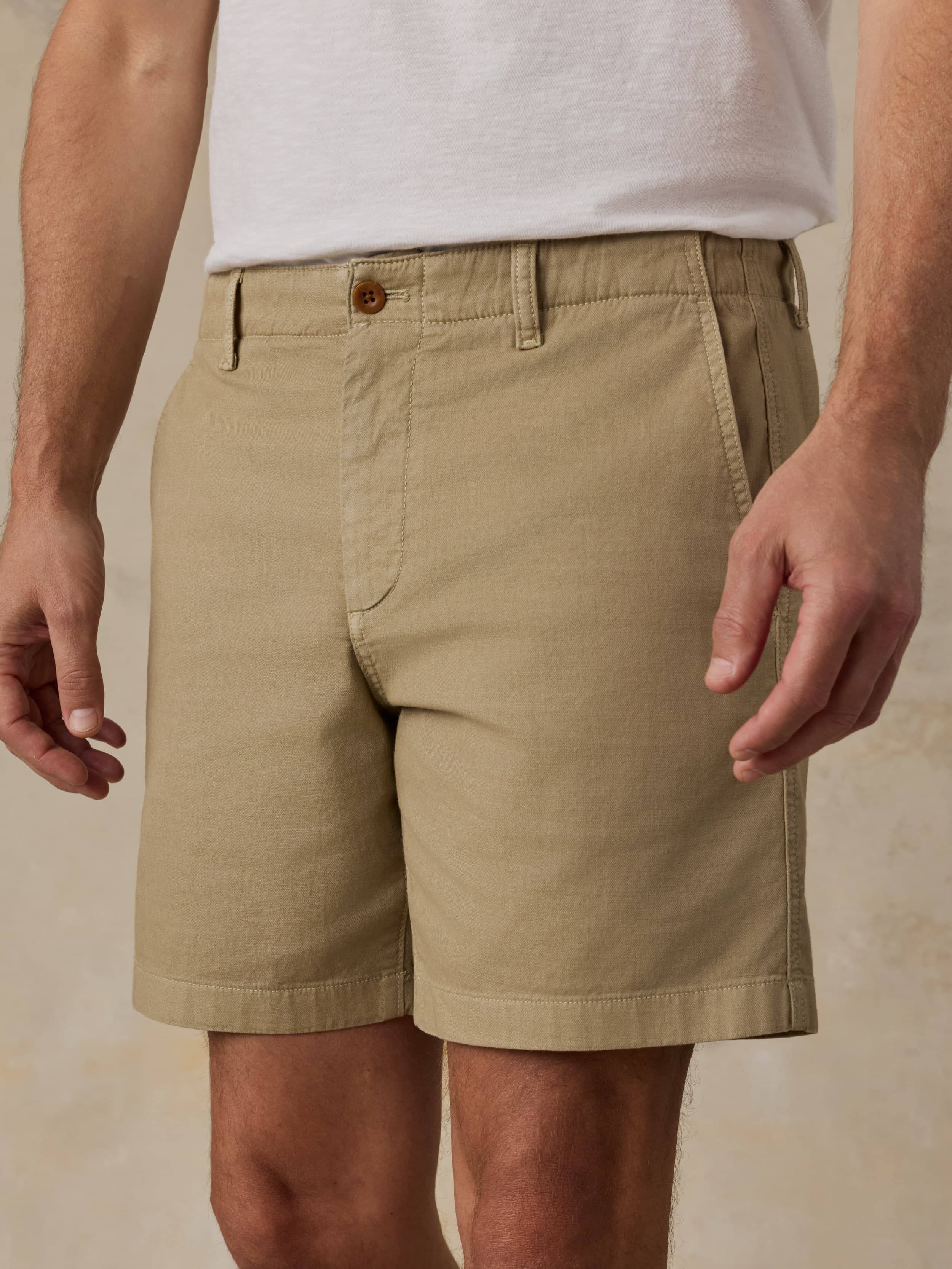 Beige shorts worn by a man on a beige background