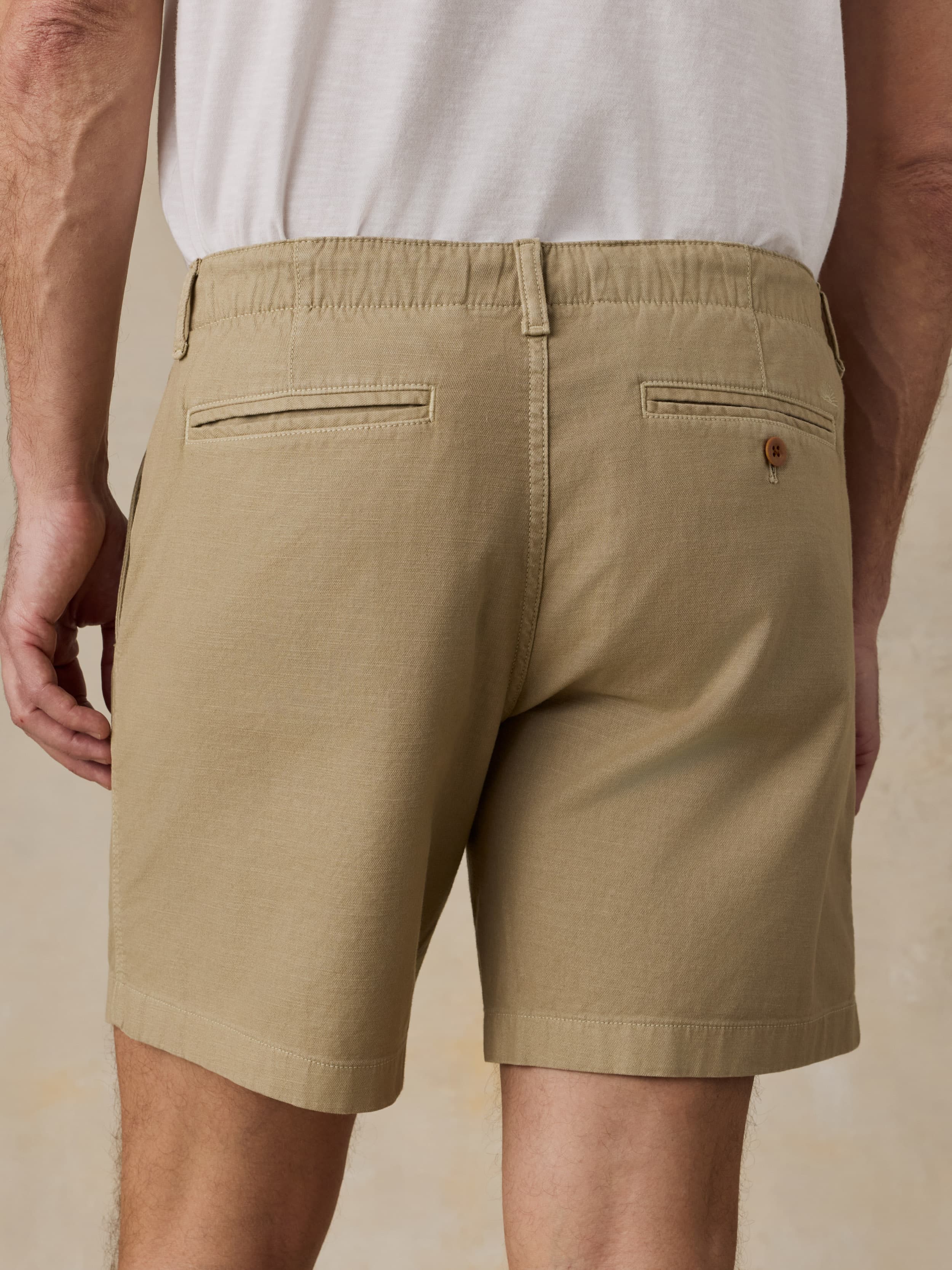 Beige shorts worn by a man on a beige background
