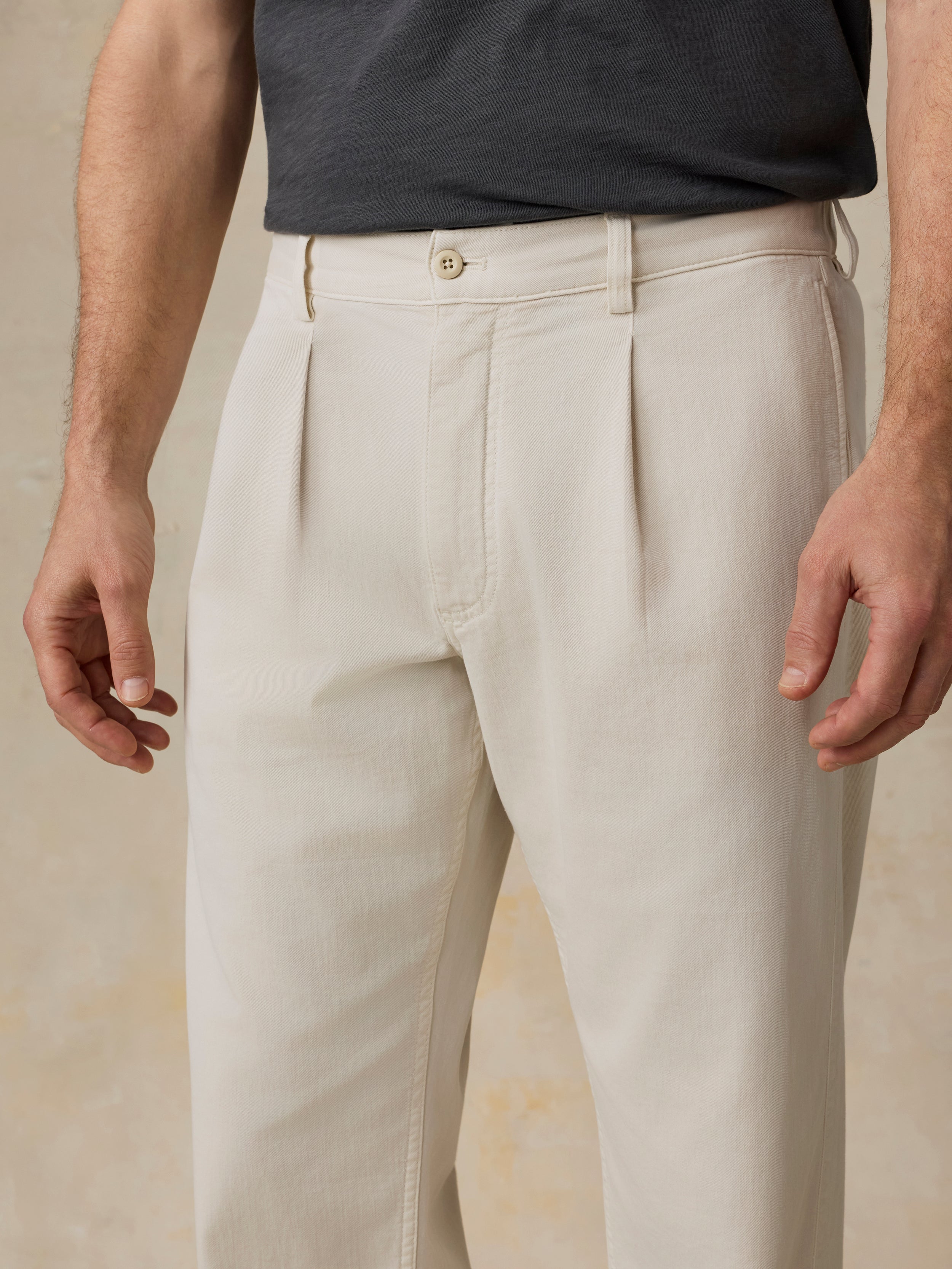 Beige pants worn by a man on a neutral background