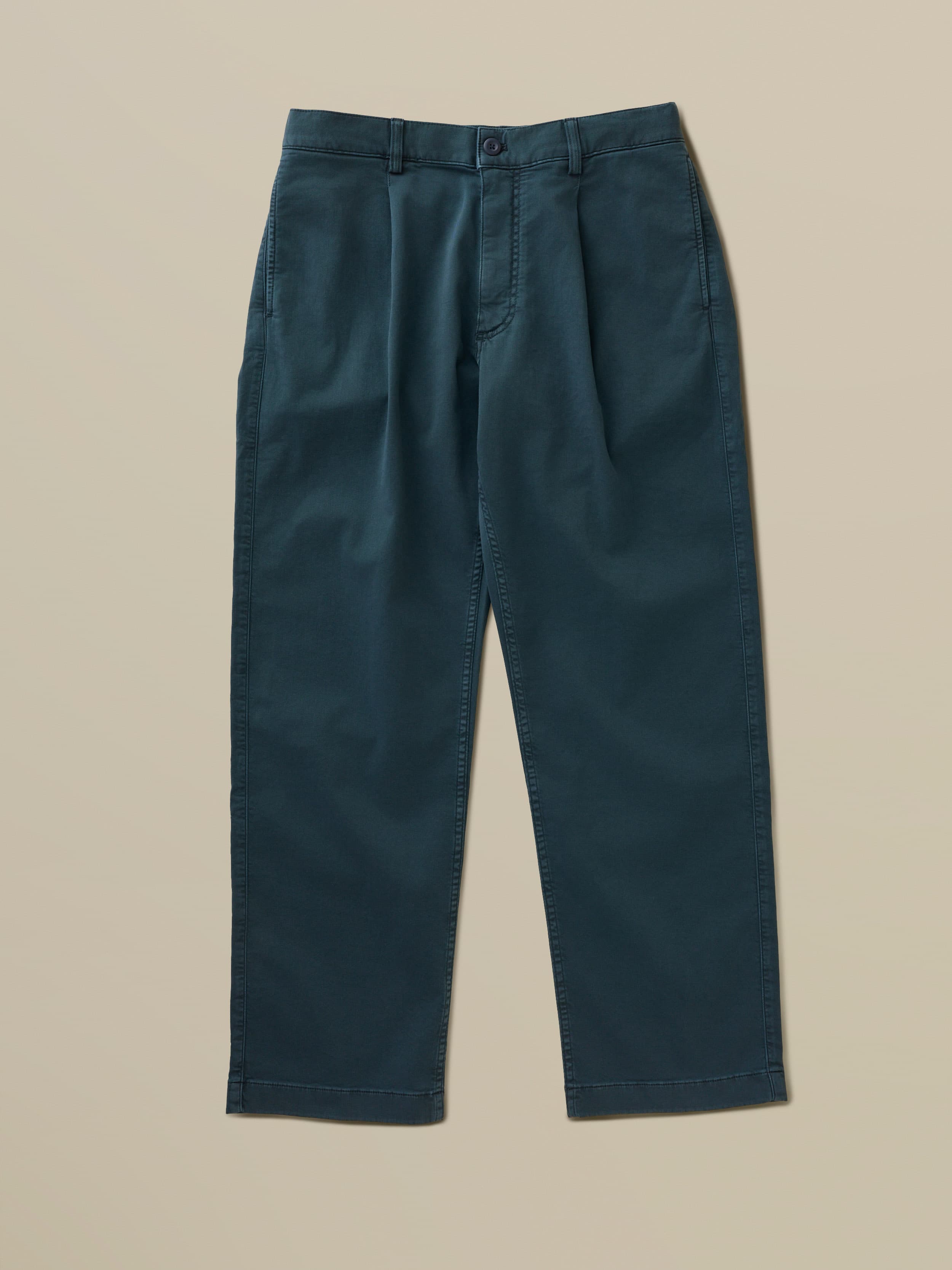 Blue khaki pants against a beige background