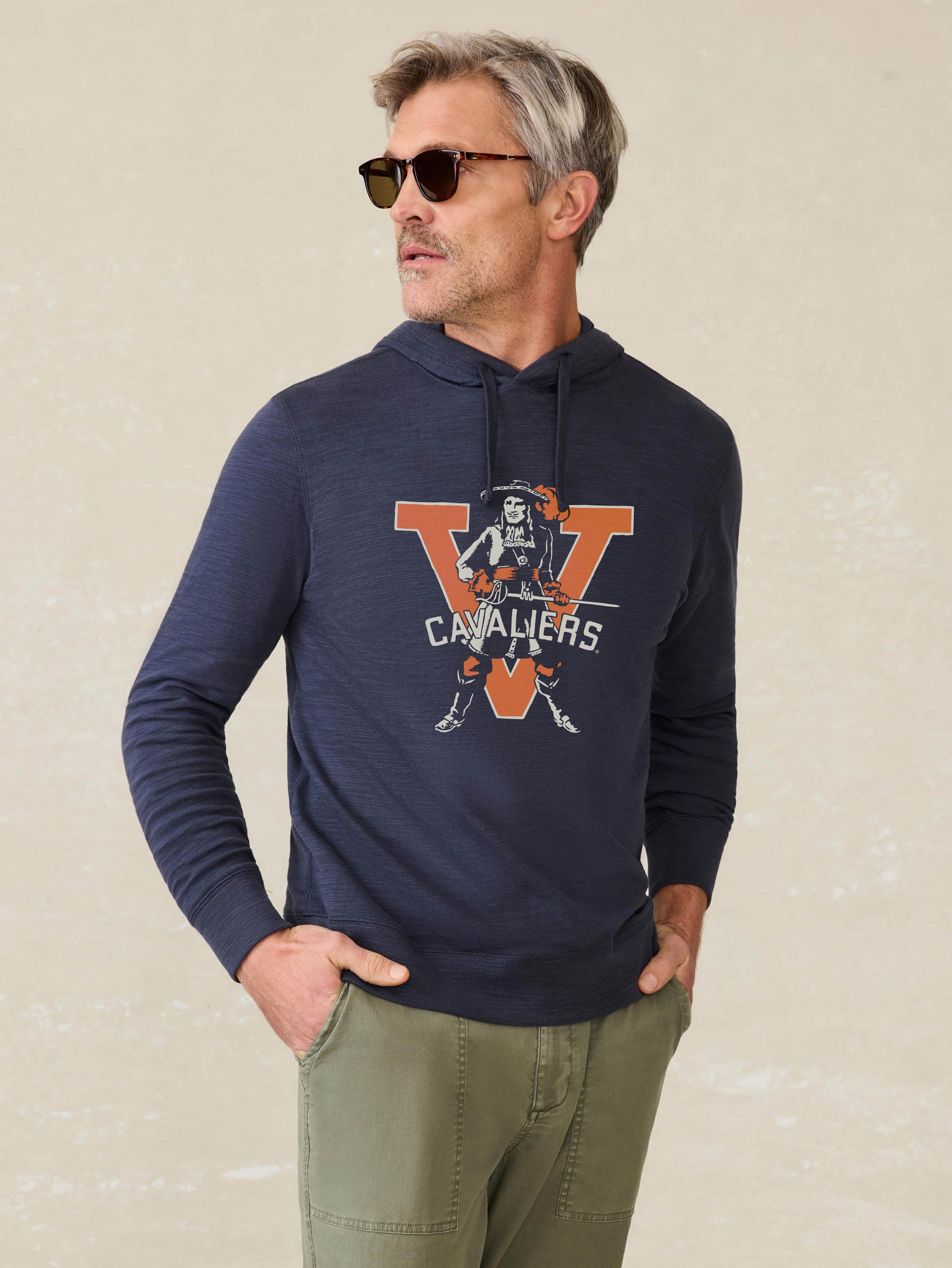 Man wearing a navy hoodie with University of Virginia graphic at the center chest against a beige background