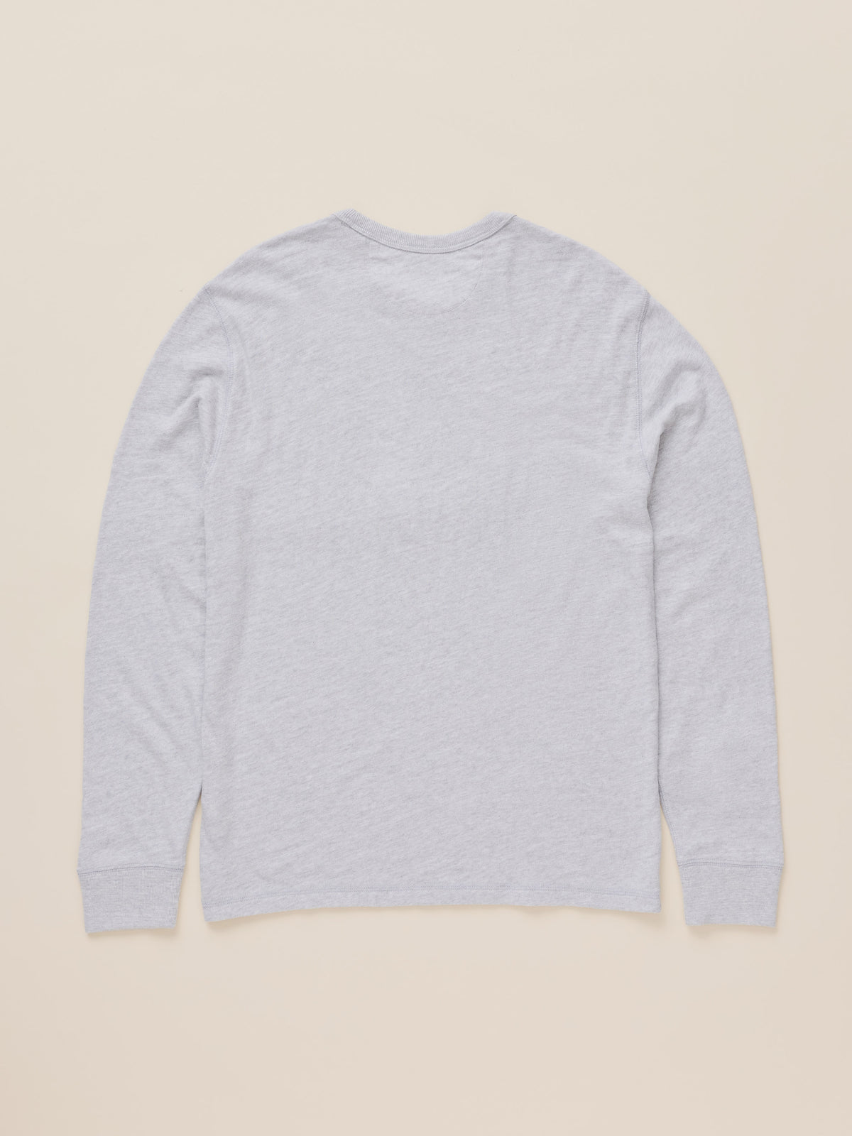 A light gray heather long-sleeve t-shirt shown from the back, laid flat against a solid beige background., image 8 of 8