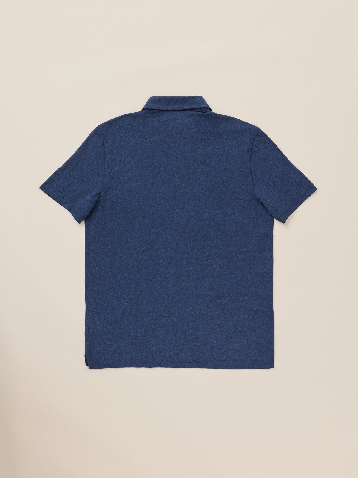 A blue short-sleeve polo shirt against a warm beige studio background, image 8 of 8