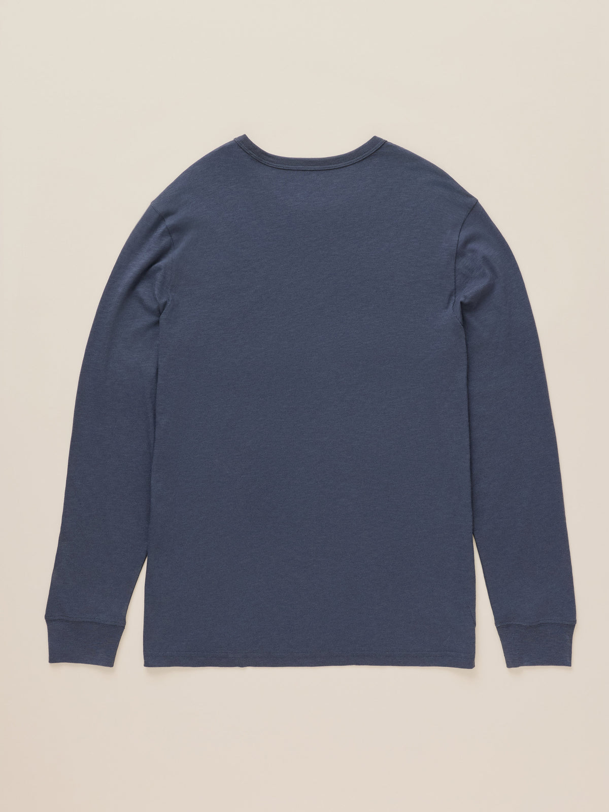 A navy blue long-sleeve crewneck shirt shown from the back, laid flat against a light beige background., image 7 of 7