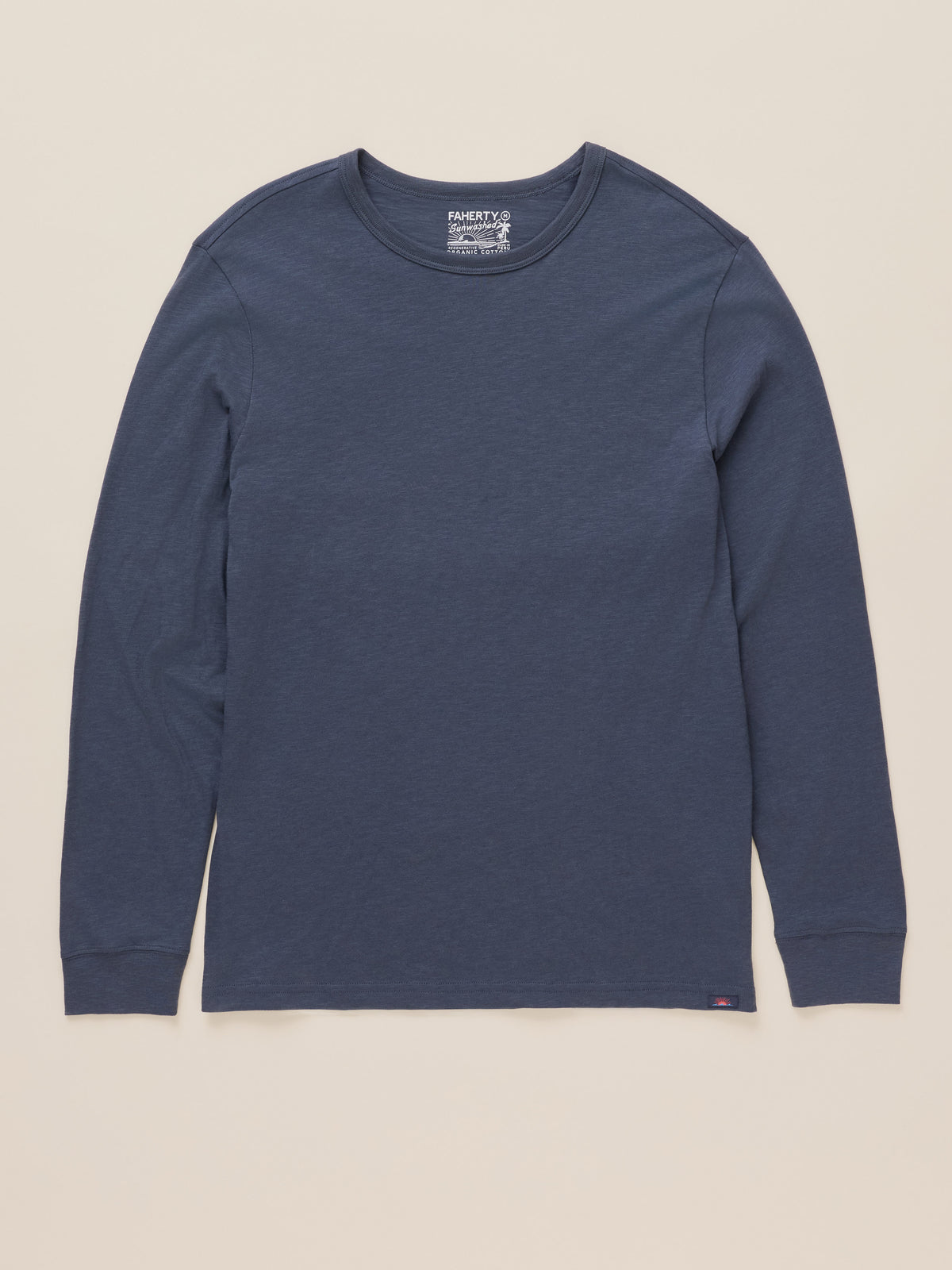 A dark blue long-sleeve crewneck shirt by Port & Company, laid flat against a light beige background., image 6 of 7