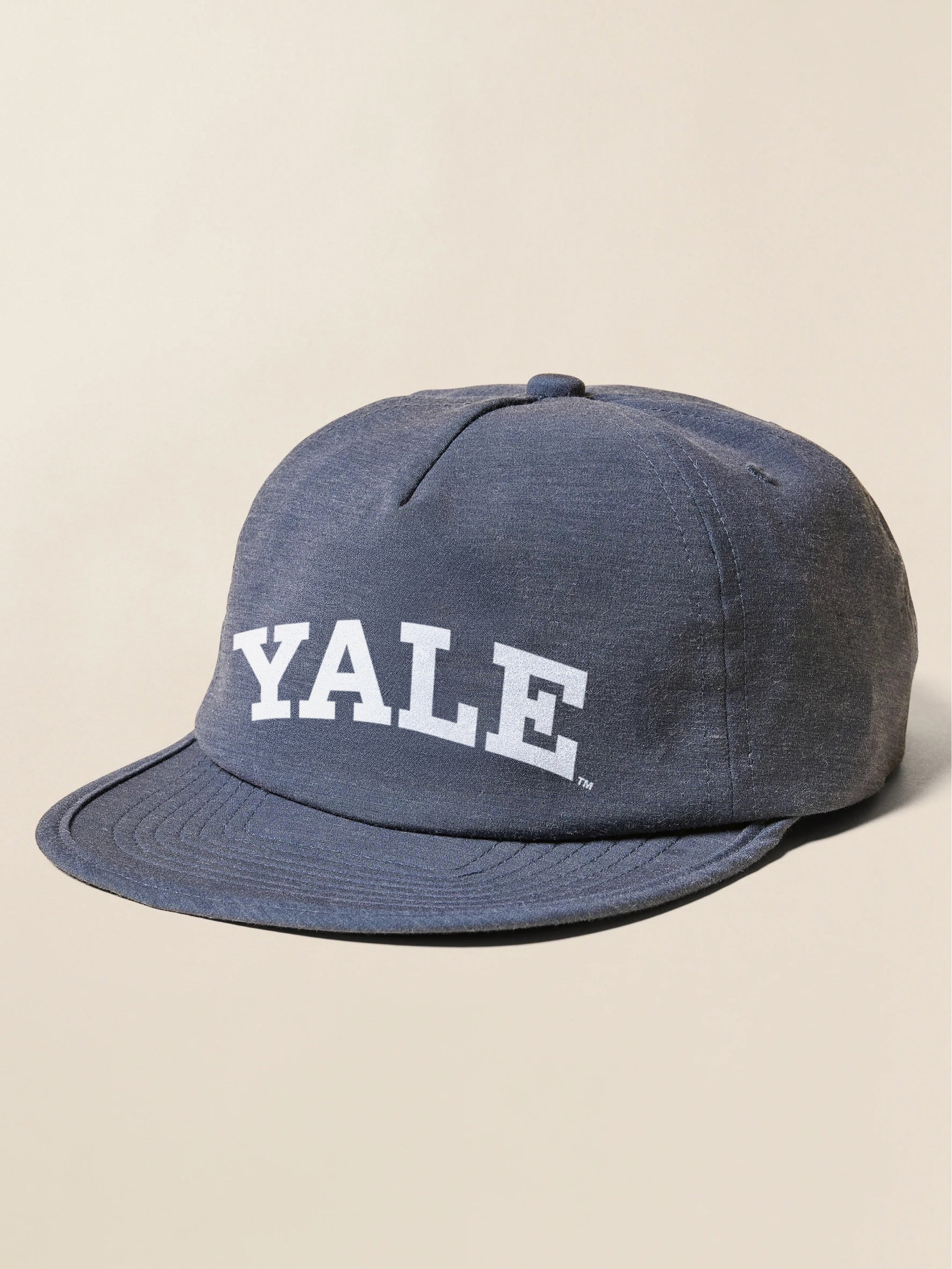 Blue hat with Yale logo at the front against a beige background