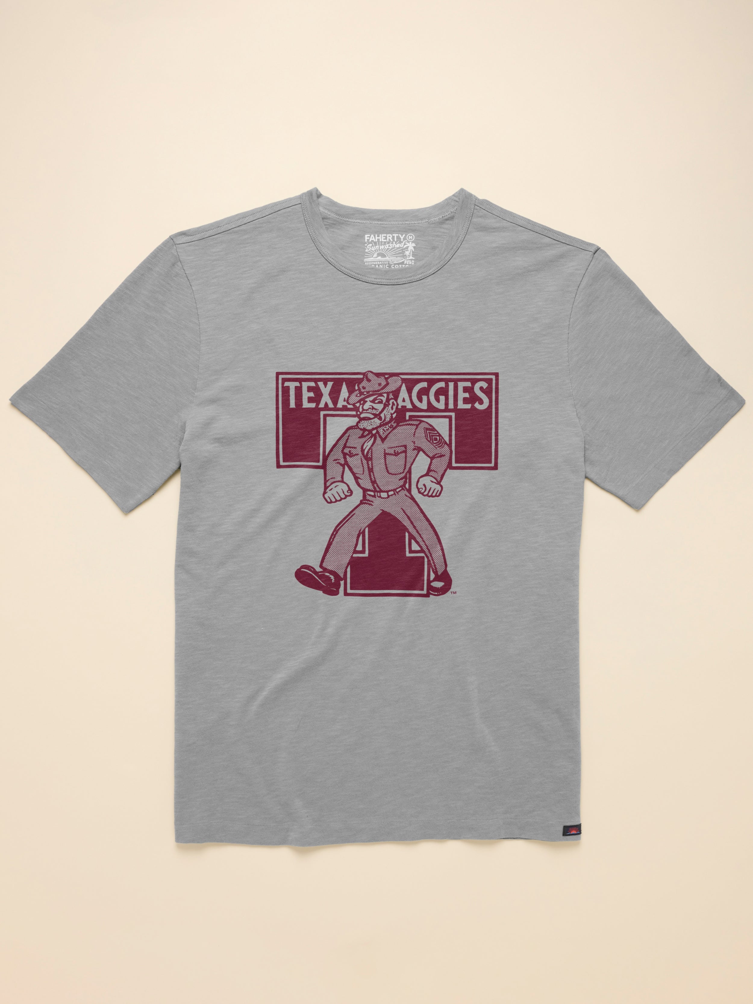 Grey t-shirt with Texas A&M graphic on front against a beige background