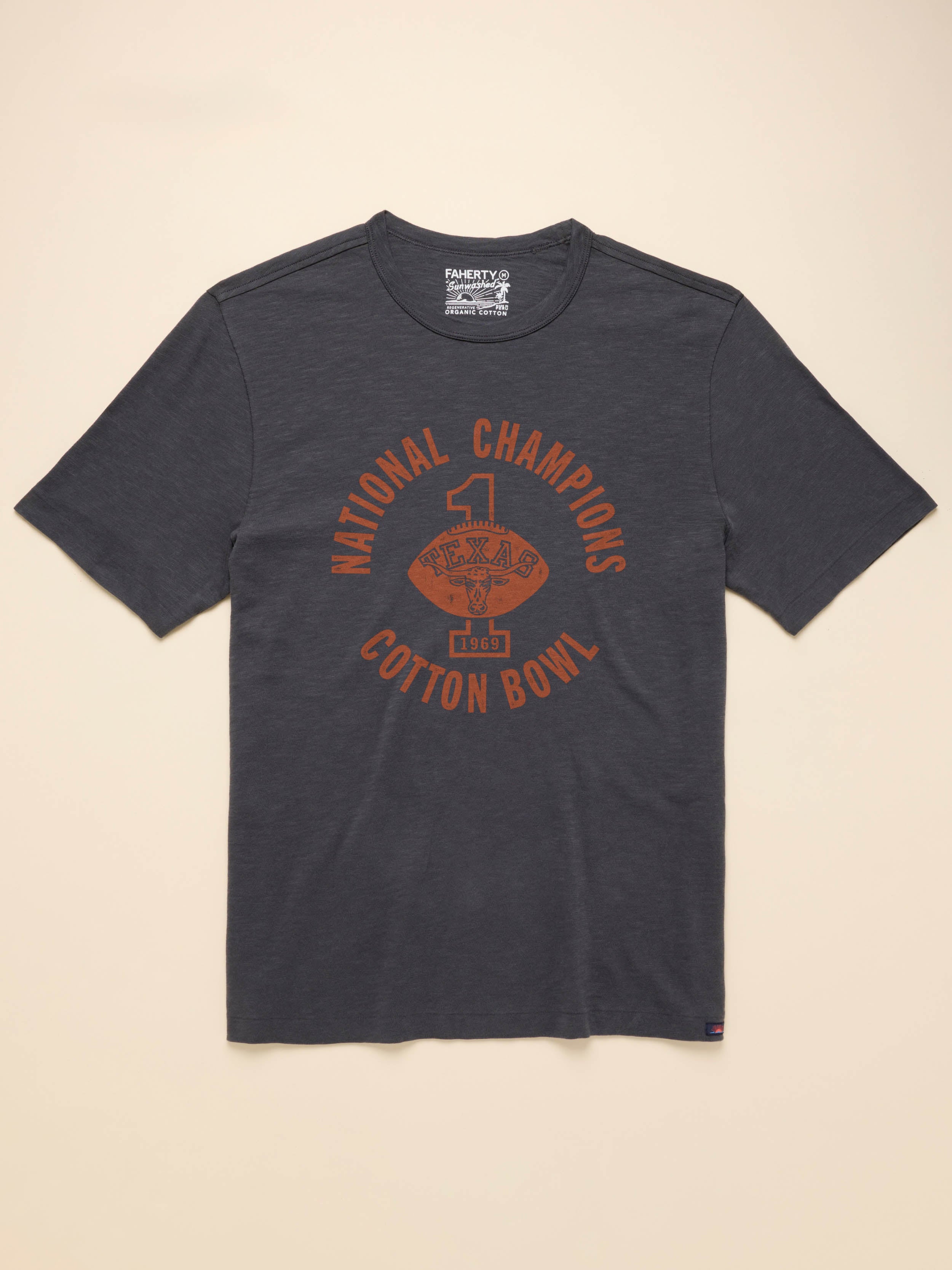 Grey short sleeve t-shirt with UT Austin graphic on center front against a beige background