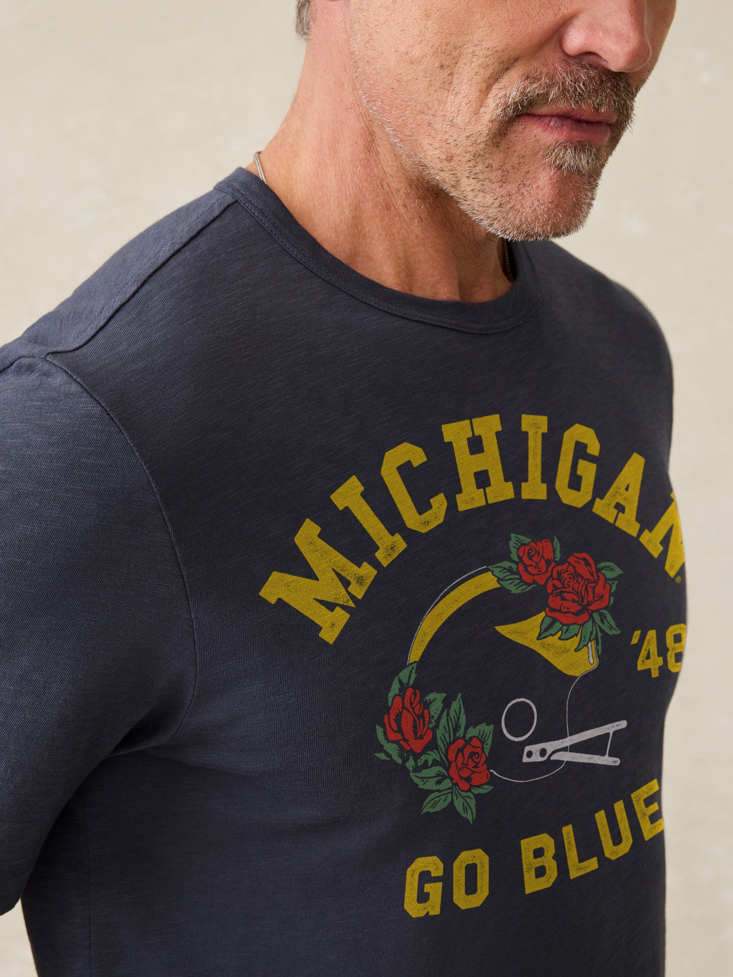 Navy t-shirt with Michigan graphic against a beige background