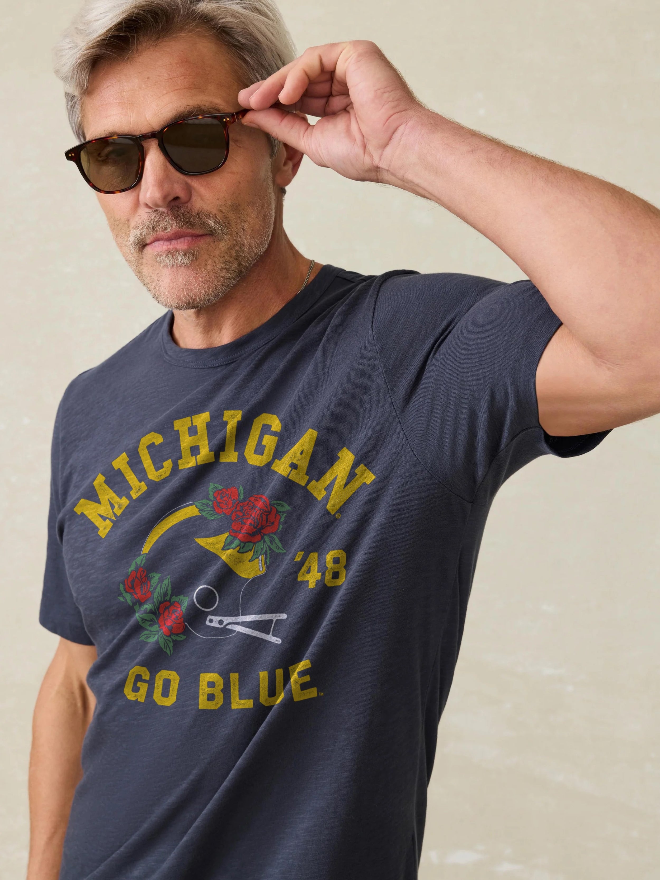 Navy t-shirt with Michigan graphic against a beige background