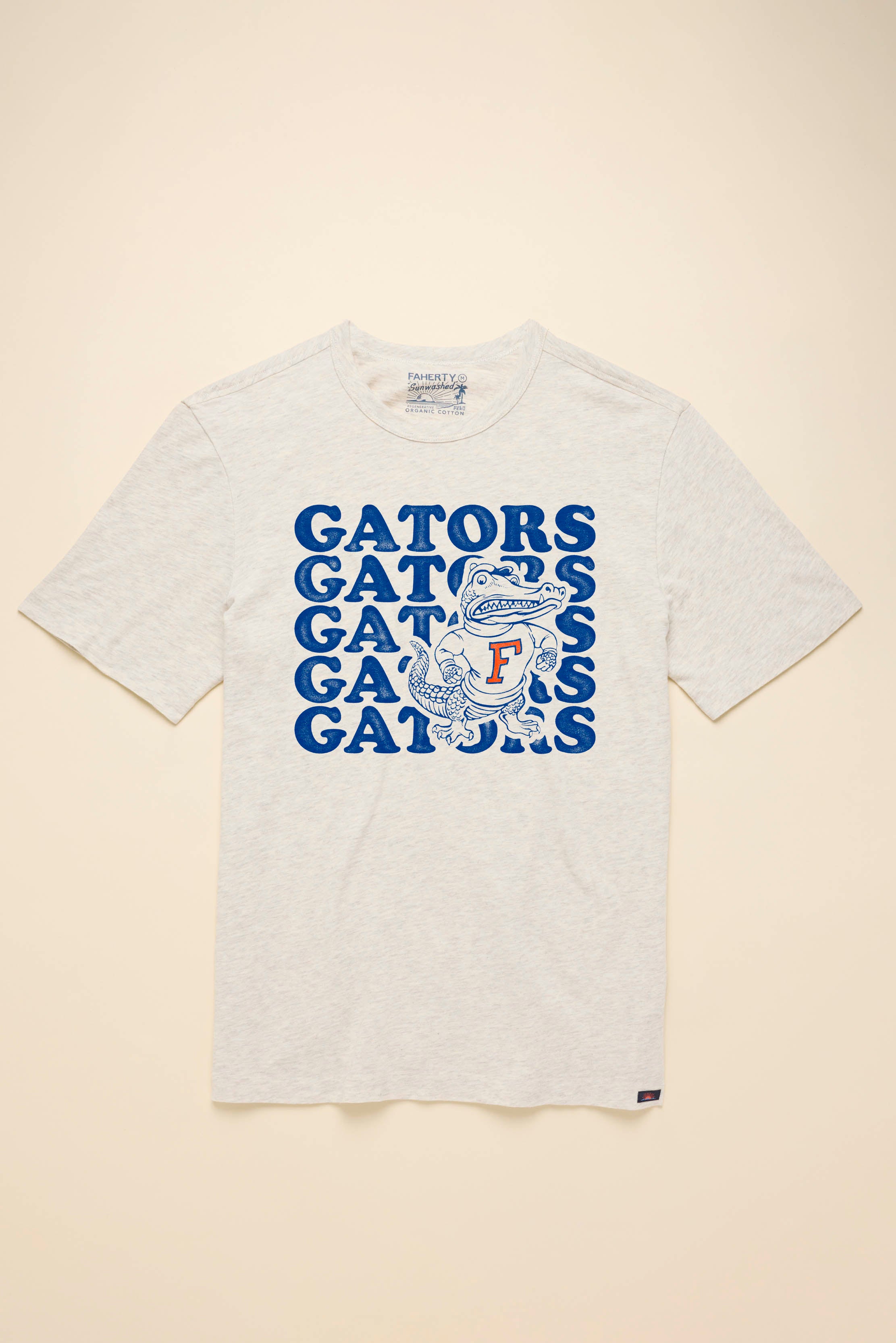 A white short-sleeve t-shirt with University of Florida graphic at the center front against a beige background