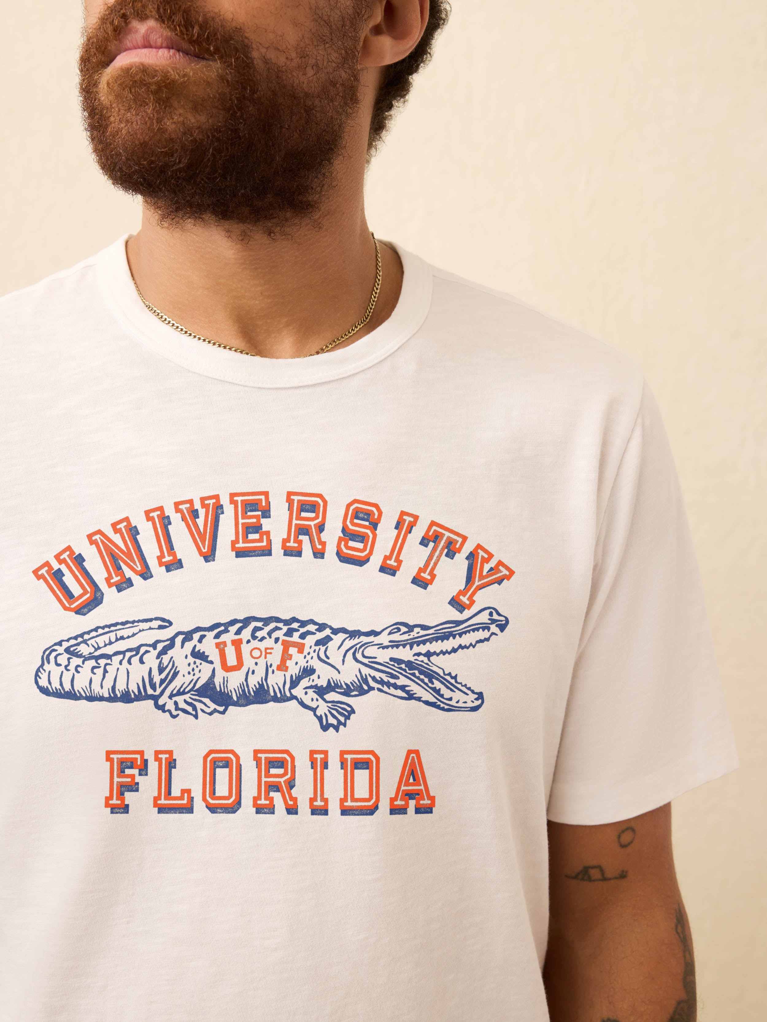 White t-shirt with University of Florida graphic on the front against beige background