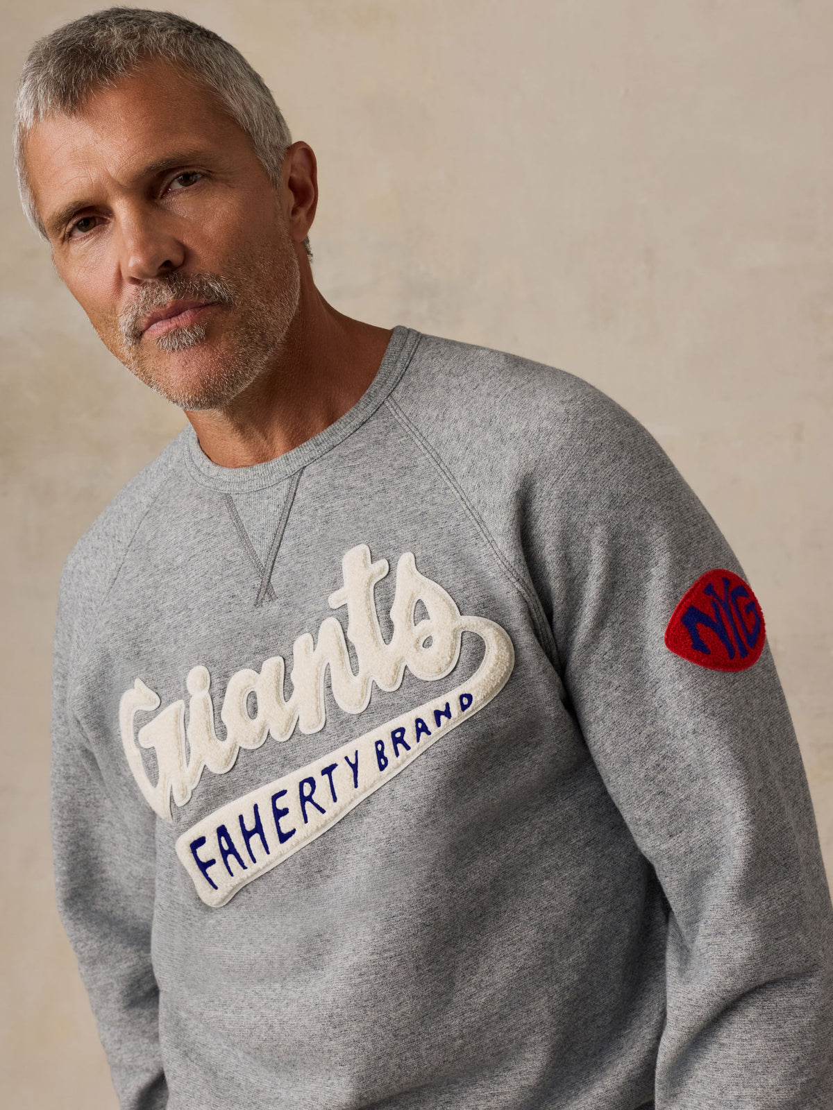 A man wearing a grey NY Giants crewneck, image 3 of 5