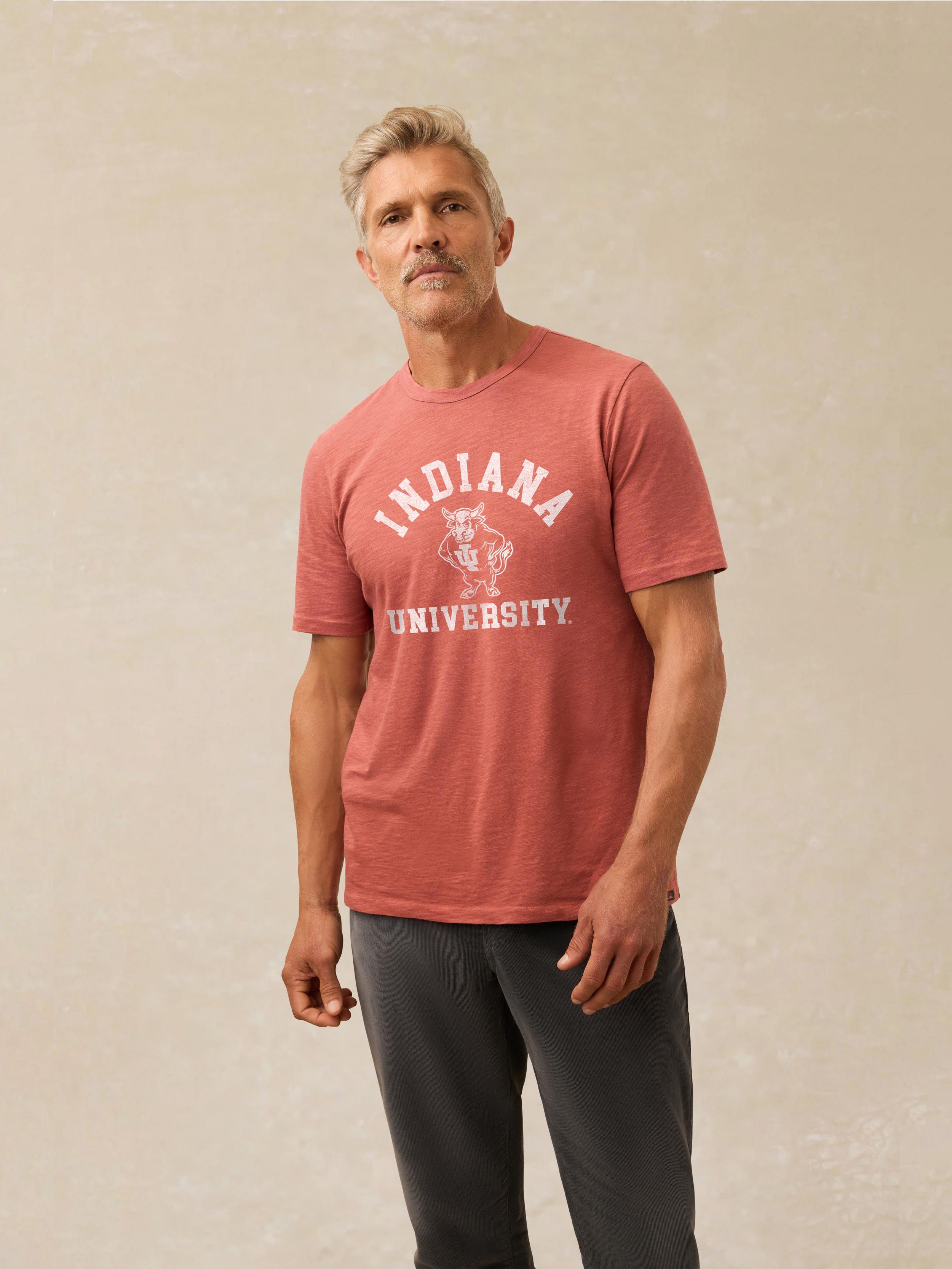 A man wearing a red Indiana University tee and black sweatpants