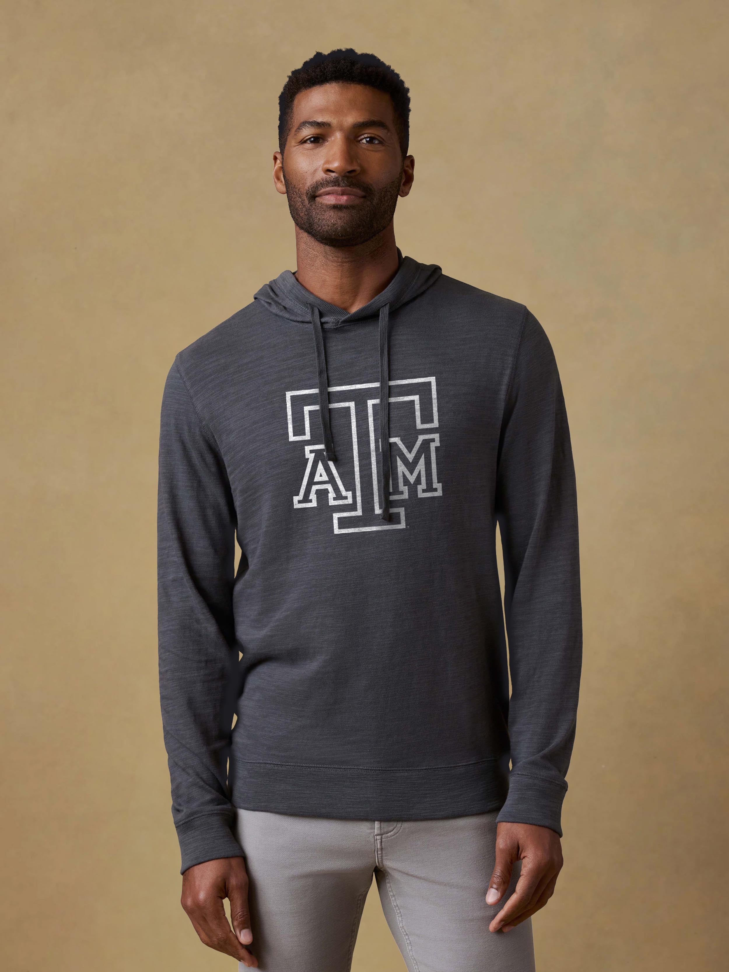 A man wearing a grey Texas A&M hoodie and light grey pants