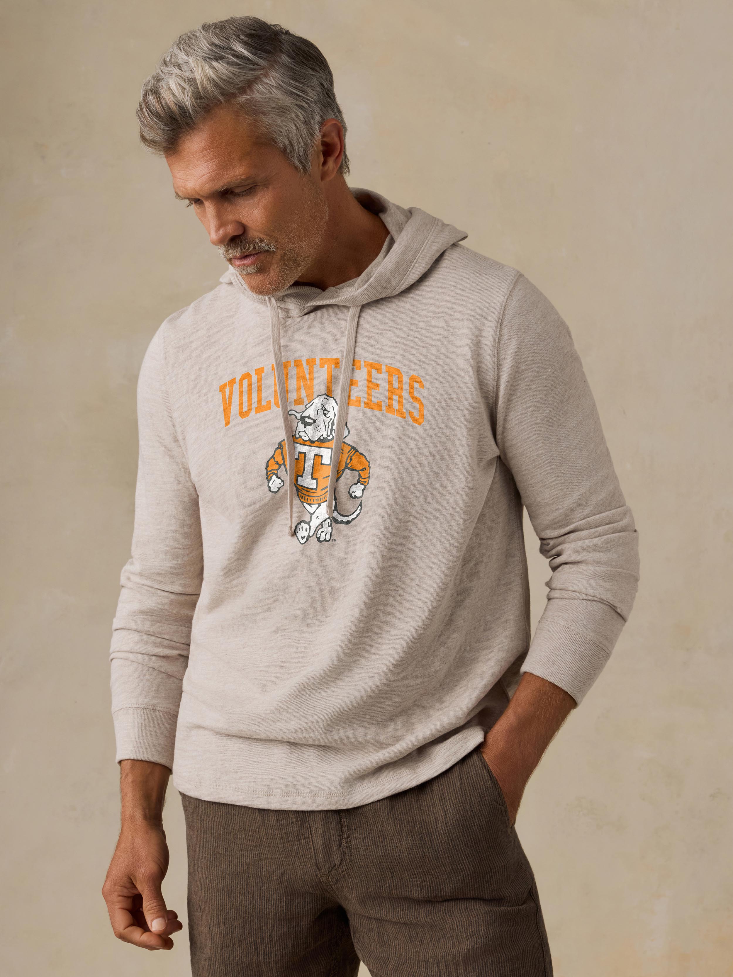 A man wearing a grey University of Tennessee  hoodie and brown shorts