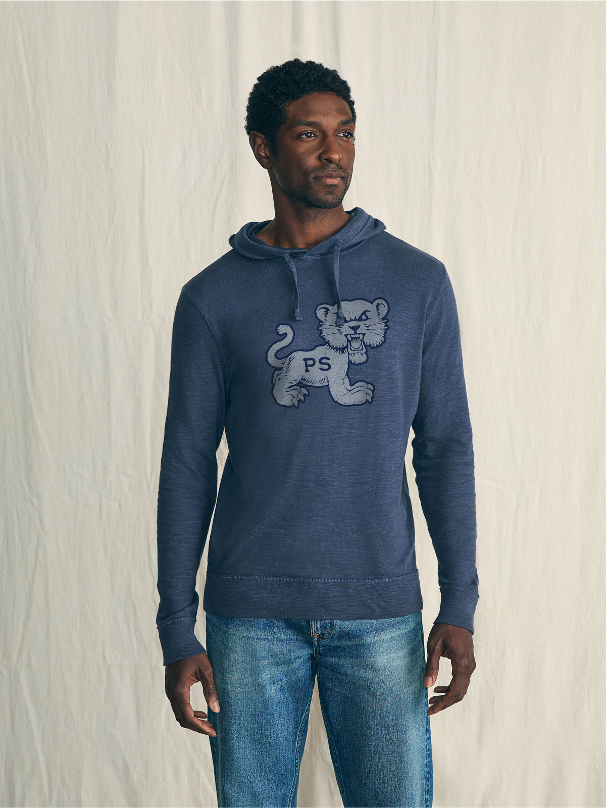 A man wearing a blue Penn State hoodie and blue jeans, image 1 of 1