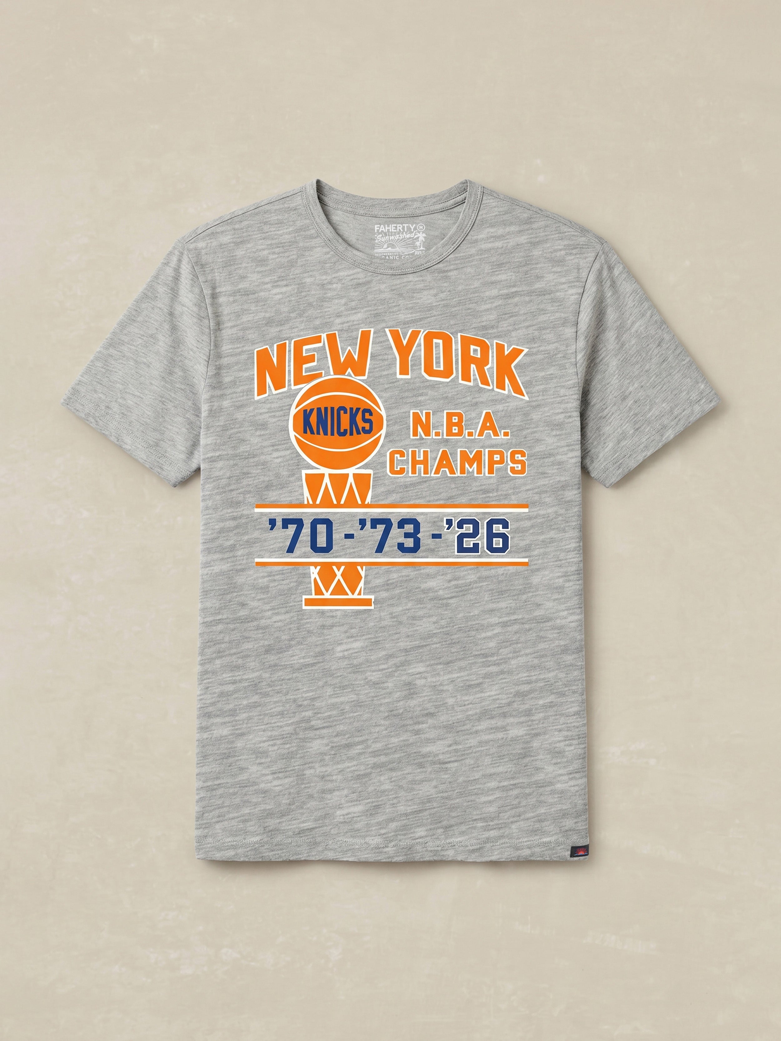 Gray t-shirt with New York Knicks NBA Champs graphic on the center chest against a beige background