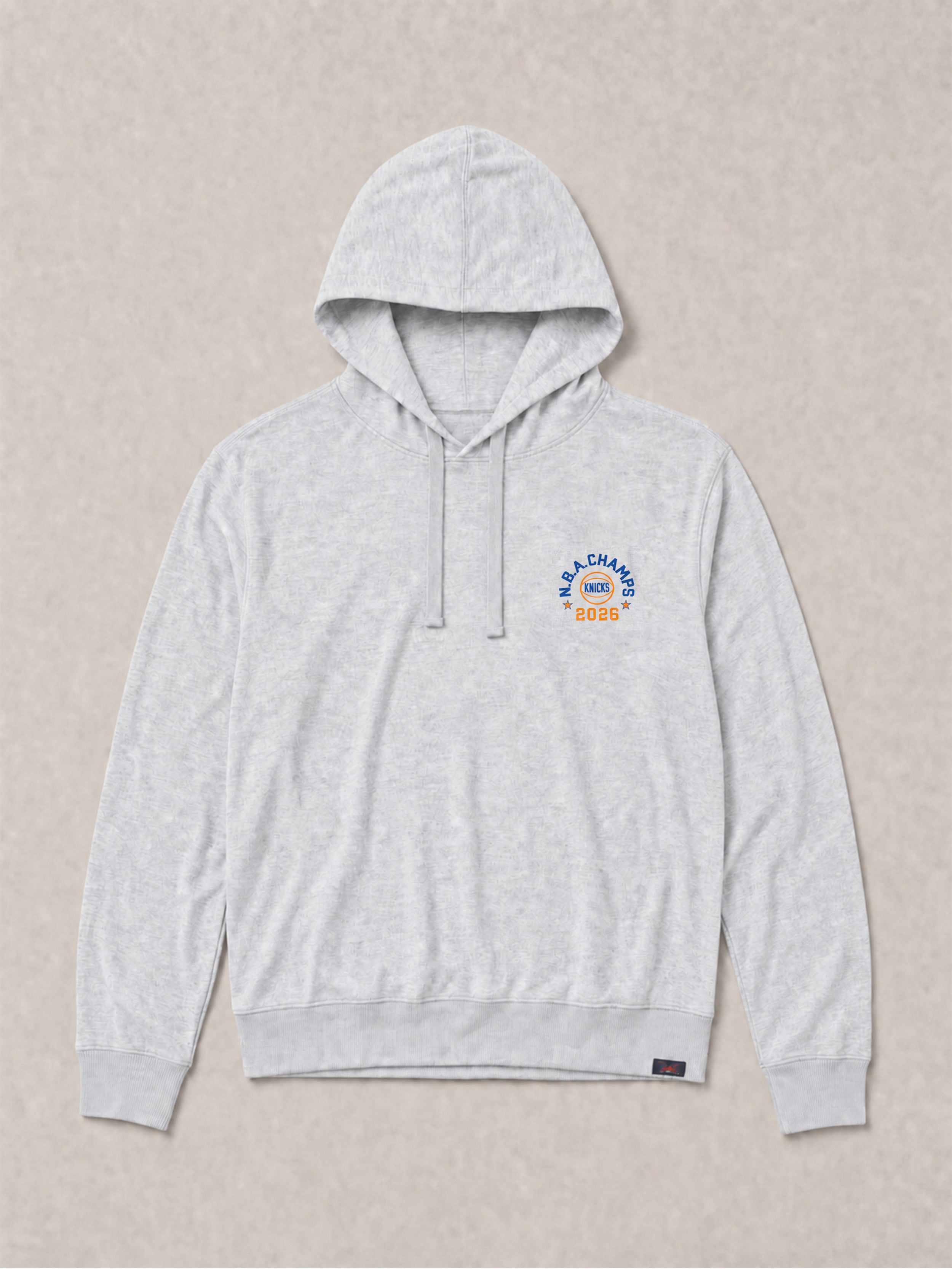 Gray hoodie with a NY Knicks graphic on the left chest against a beige background