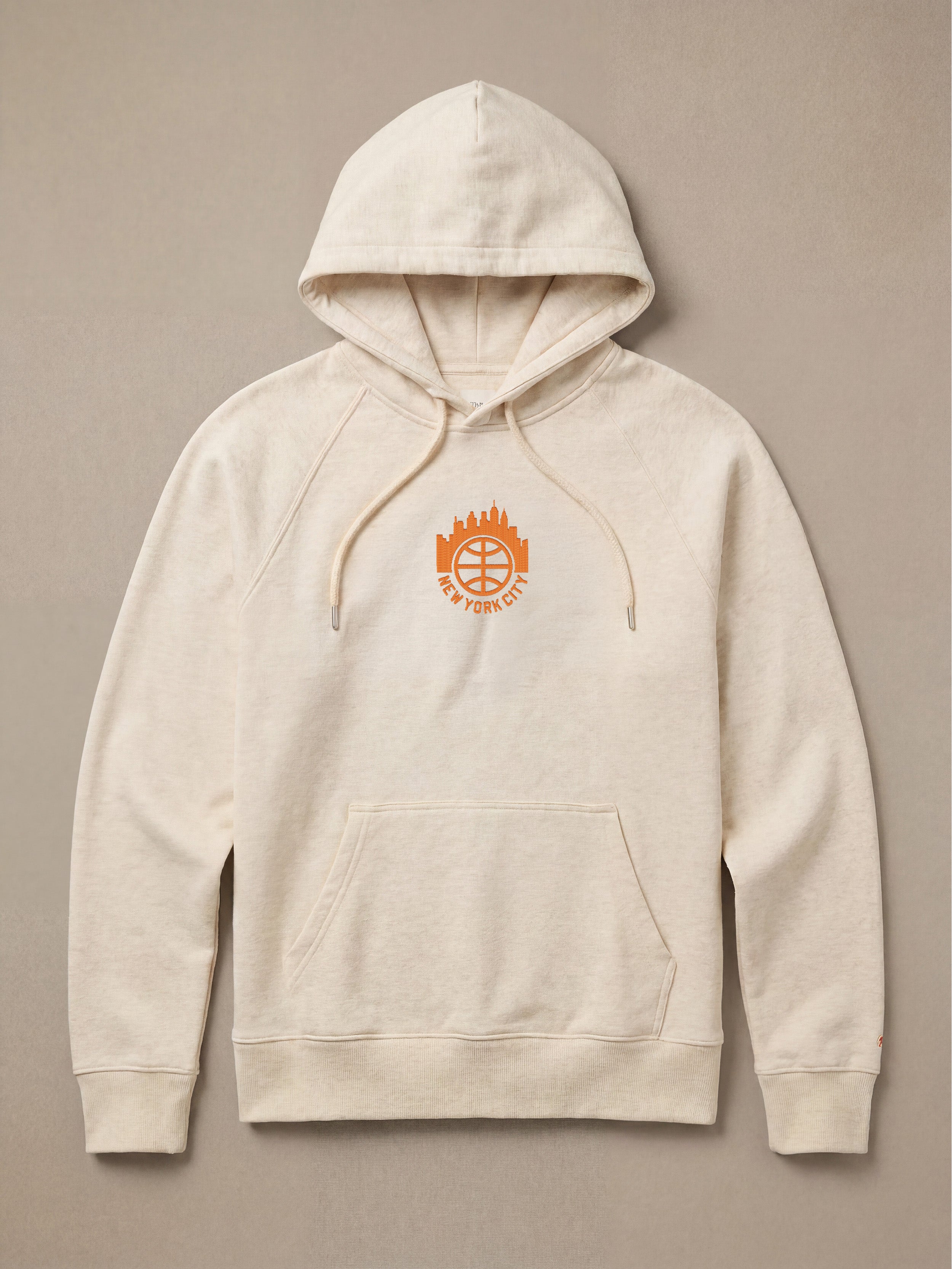 Heather hoodie with "New York City" graphic logo on the center front against a beige background